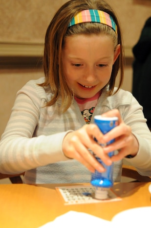 Gwen Rast marks her bingo card after a number is called during Family Night at the Charleston Club March 4, 2010, at Joint Base Charleston, S.C. Families enjoyed pizza, spaghetti, ice cream and bingo at this month's event. The next scheduled Family Night is set for April 1, 2010. Gwen is the daughter of Maj. David Ferguson who is with the 315th Airlift Wing. (U.S. Air Force photo/Staff Sgt. Marie Brown)