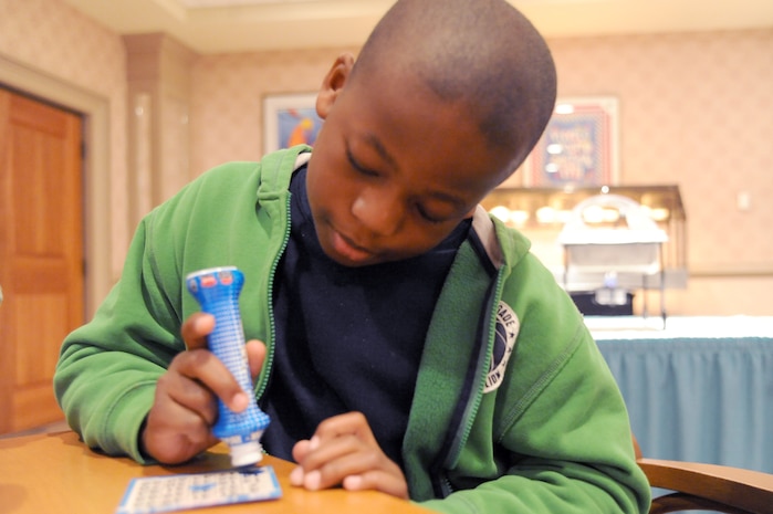 Christopher Shropshire marks his bingo card after a number is called during Family Night at the Charleston Club March 4, 2010, at Joint Base Charleston, S.C. Families enjoyed pizza, spaghetti, ice cream and bingo at this month's event. The next scheduled Family Night is set for April 1, 2010. Christopher is the son of Senior Master Sgt. Kendrick Shropshire who is with the 437th Aircraft Maintenance Squadron. (U.S. Air Force photo/Staff Sgt. Marie Brown)