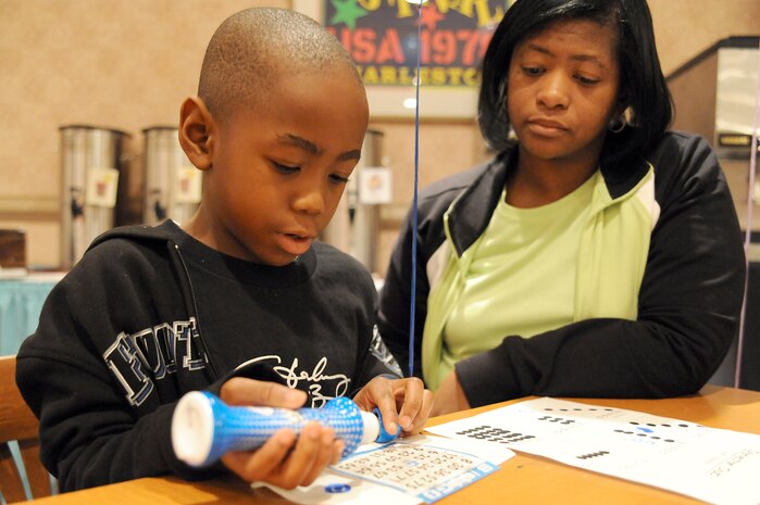 Yolanda Shropshire watches as Cameron Shropshire checks his bingo card for the called number during Family Night at the Charleston Club March 4, 2010, at Joint Base Charleston, S.C. Families enjoyed pizza, spaghetti, ice cream and bingo at this month's event. The next scheduled Family Night is set for April 1, 2010. Yolanda is the wife of Senior Master Sgt. Kendrick Shropshire who is with the 437th Aircraft Maintenance Squadron, and Cameron is their son. (U.S. Air Force photo/Staff Sgt. Marie Brown)