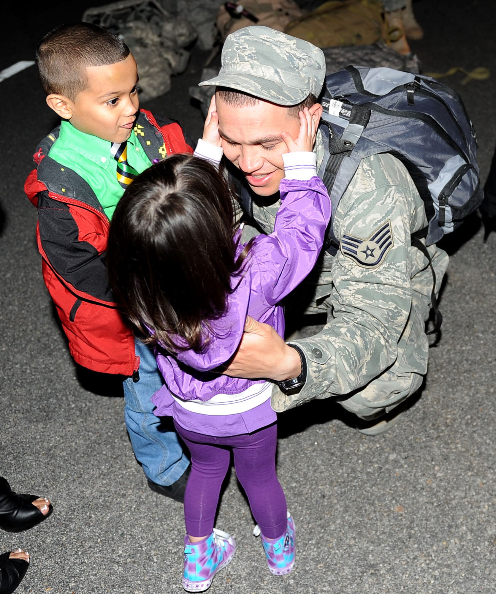 LANGLEY AIR FORCE BASE, Va. -- Staff Sgt. Michael Serrano, 633d Logistics Readiness Squadron vehicle operator, hugs his children, Rome, 5, and Lilliana, 2, during his homecoming March 5. Sergeant Serrano and eight others deployed for 200 days as Air Force Combat Convoy Vehicle Operators in support of the 586th Expeditionary Logistics Readiness Squadron at Camp Arifjan, Kuwait . (U.S. Air Force photo/Airman Rebecca Montez)