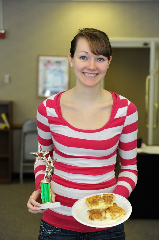 LANGLEY AIR FORCE BASE, Va. -- Airman Bethany Provot,  633d Dental Squadron general dental technician, shows off her first place trophy and winning cinnamon cheesecake after a cook-off March 6.  The 633d Force Support Squadron hosted the cook-off at the community center and plans to conduct more cooking contests in the futre. (U.S. Air Force photo/Senior Airman Zachary Wolf)
