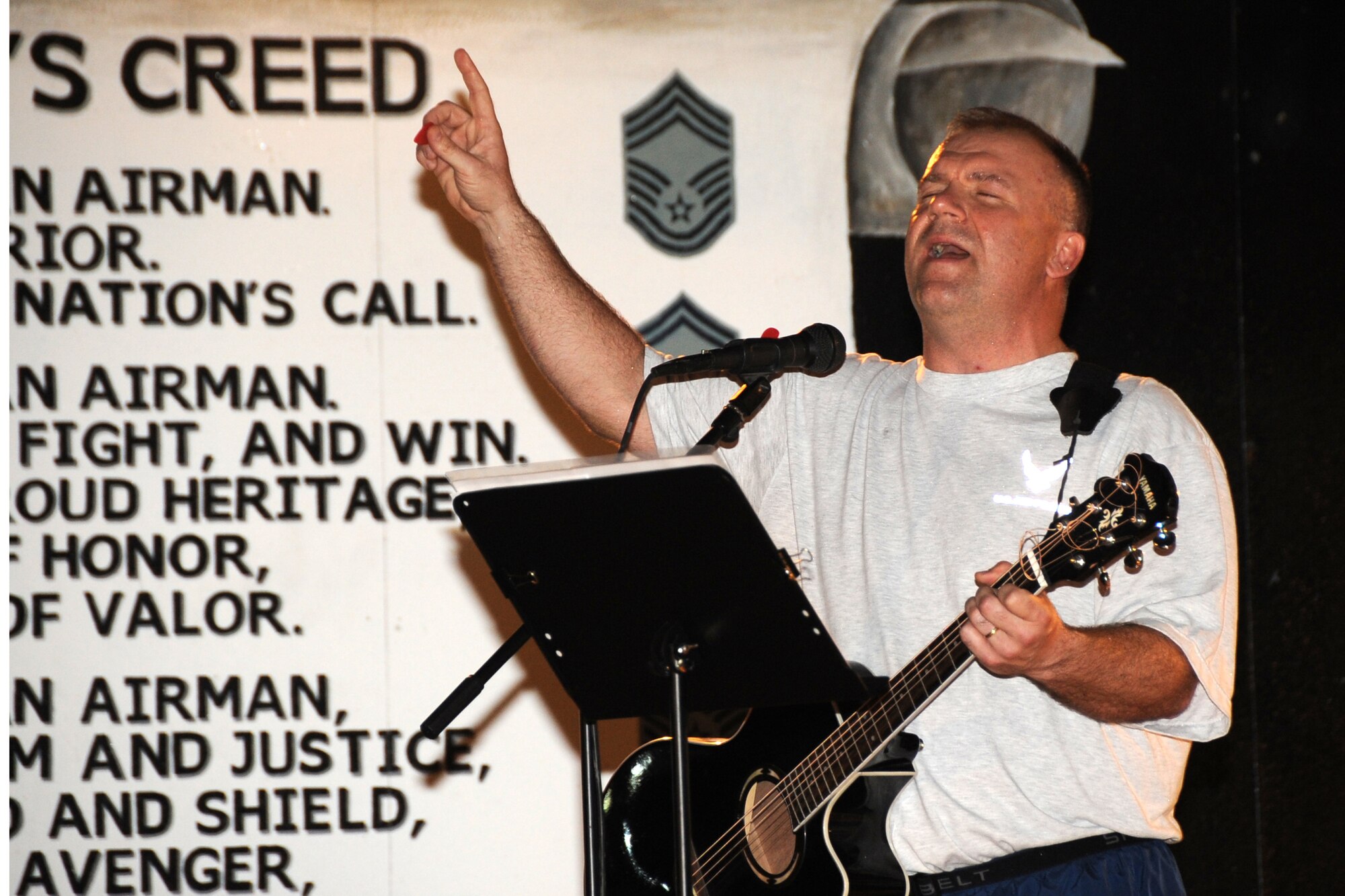Senior Master Sgt. Robert Martin, 380th Expeditionary Civil Engineer Squadron first sergeant, plays the guitar and sings during the 380th Air Expeditionary Wing "Gospel Explosion" musical event at an undisclosed location in Southwest Asia on March 6, 2010. Members of various worship services musical groups joined together for a concert with special guest (Ch.) Maj. Gen. Cecil Richardson, Air Force Chief of Chaplains, speaking. The 380th AEW supports Operations Iraqi Freedom and Enduring Freedom and the Combined Joint Task Force-Horn of Africa. The 380th AEW is comprised of four groups and 12 squadrons and the wing's deployed mission includes air refueling, surveillance and reconnaissance in support of overseas contingency operations in Southwest Asia. (U.S. Air Force photo/Senior Airman Jenifer H. Calhoun/Released)