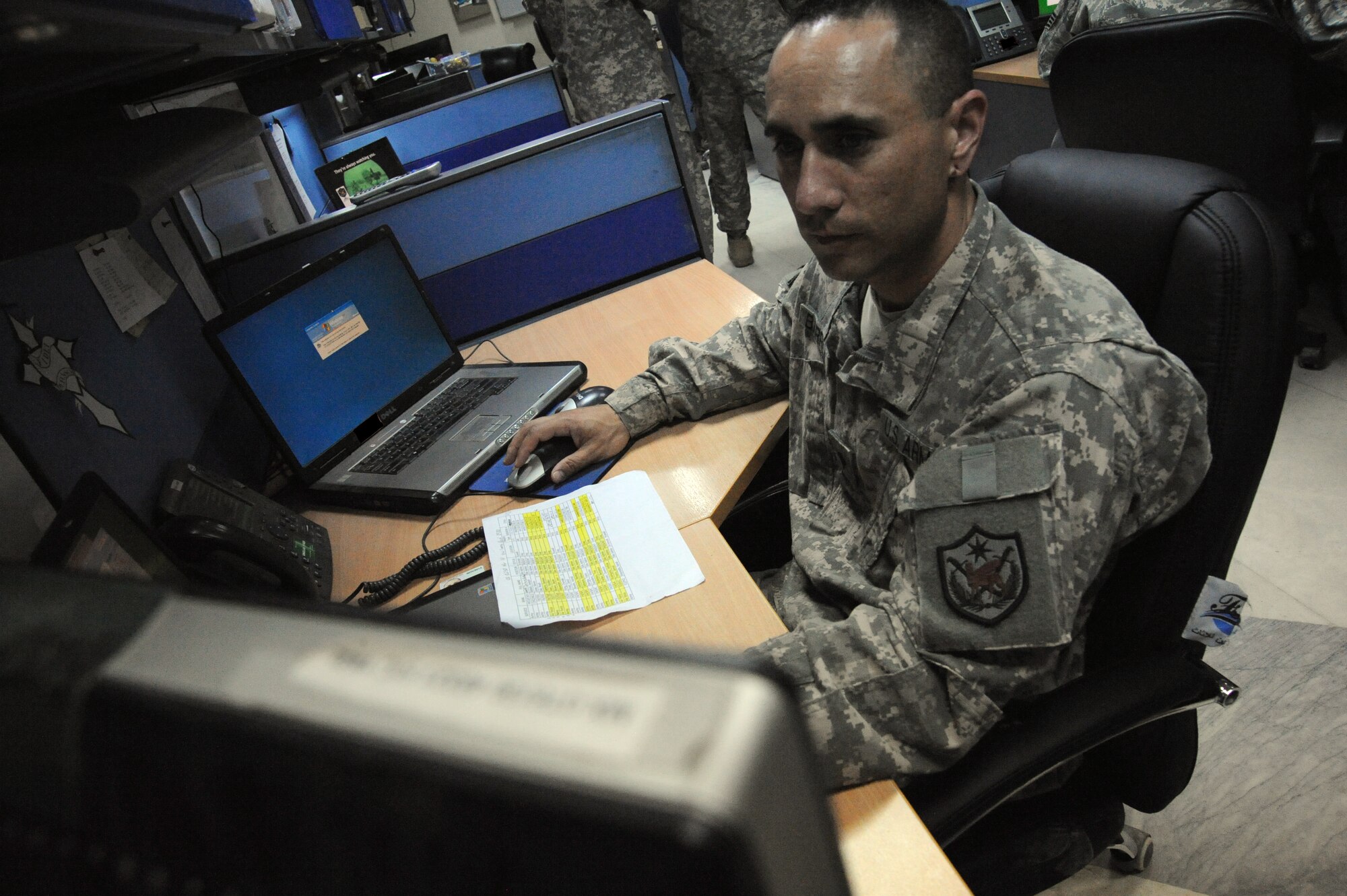 U.S. Army Specialist Travis Barriga, United States Forces-Iraq computer information administrator, works on a trouble ticket at his desk on Camp Victory, Iraq, March 4, 2010 The mission of the Airman and Soldiers in the United States Forces- Iraq J6 communications directorate server room is to provide network core services on both secret internet protocol and non-secure internet protocol routers throughout Camp Victory. (U.S. Air Force photo/Master Sgt. Trish Bunting/Released)
