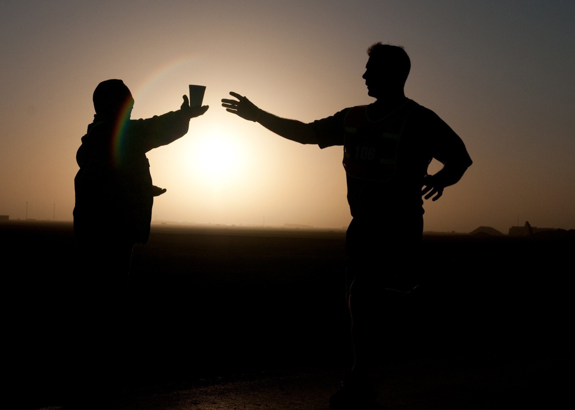 A marathon runner reaches for a cup of water at mile-marker nine drink and
aid station during the El Paso Half-Marathon, a 13.1 mile course throughout
Contingency Operating Base Adder, Iraq, Feb. 26, 2010. Over 450 Airmen,
Soldiers, Sailors and civilians participated in the Fort Bliss, Texas
sponsored event. (Photo by Senior Master Sgt. Elizabeth Gilbert/released) 
