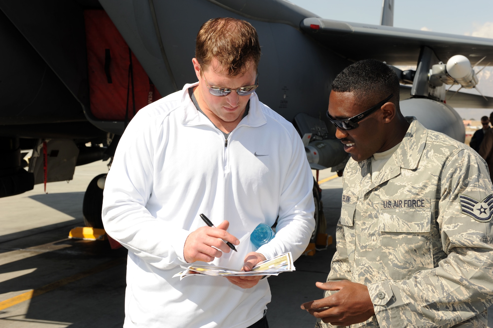 Jason Witten of the Dallas Cowboys signs an autograph for Staff Sgt. Arthur Belvin, 455th Expeditionary Aircraft Maintenance Squadron aircraft weapons loader, during a recent National Football League player visit to Bagram Airfield, March 5, 2010. The NFL players are on a USO-sponsored tour of the U.S. Central Command area of operations. (U.S. Air Force photo/Staff Sgt. Richard Williams)