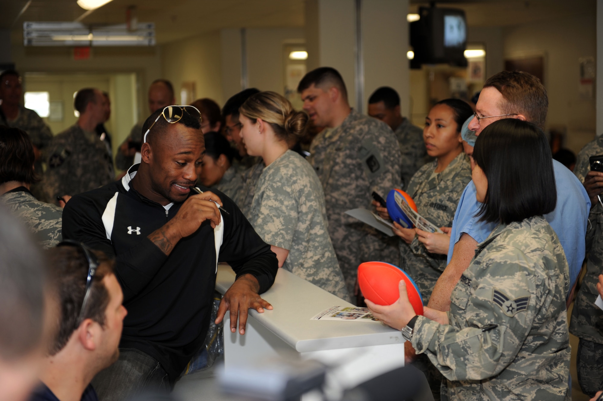 Vernon Davis, tight end for the San Francisco 49ers, signs autographs for servicemembers at the Craig Joint Theater Hospital on Bagram Airfield, March 5, 2010. The National Football League players are on a USO-sponsored tour of the U.S. Central Command area of operations. (U.S. Air Force photo/Staff Sgt. Richard Williams)