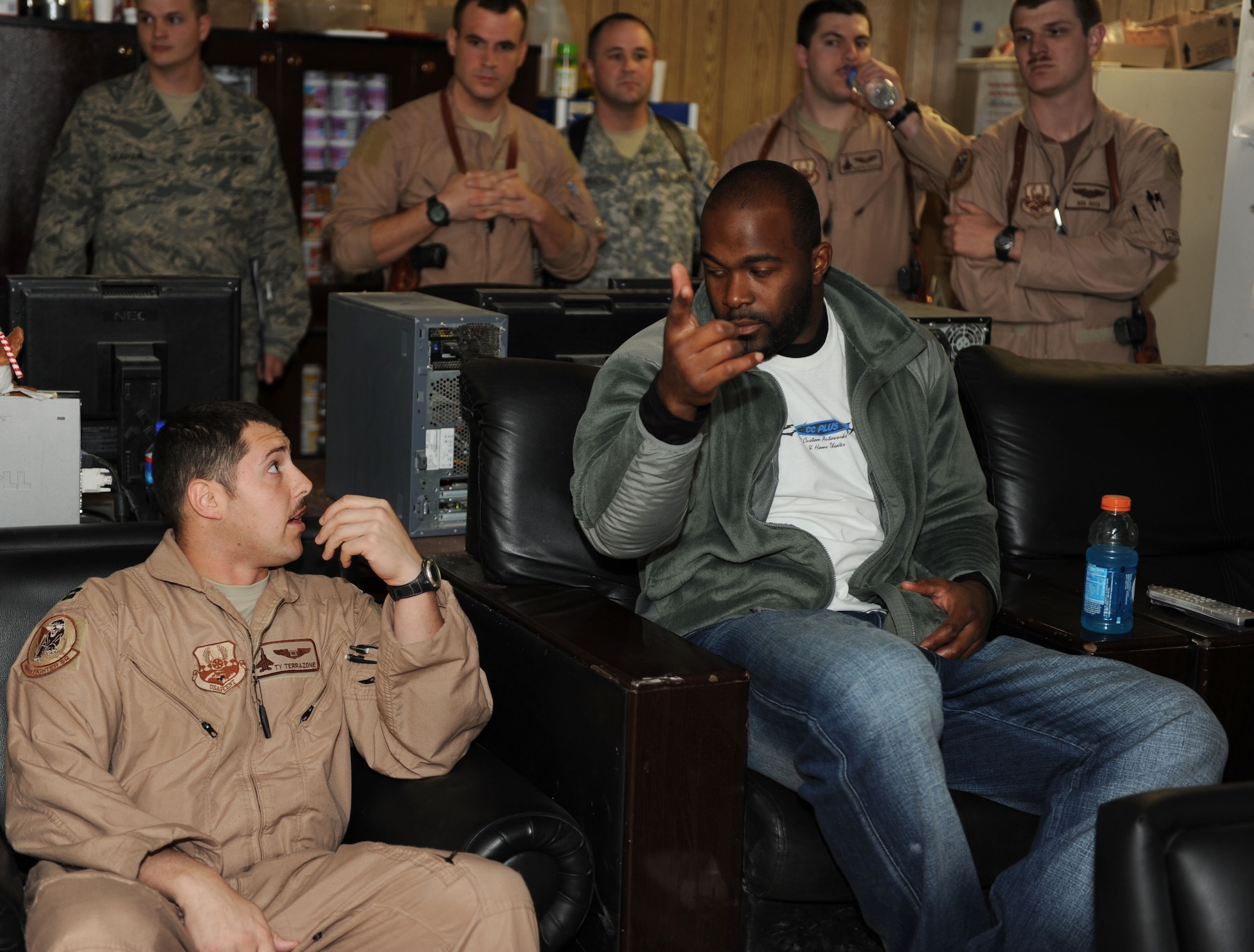 U.S. Air Force Capt. Tyler Terrazone, 494th Expeditionary Fighter Squadron F-15E weapons system officer, and Mario Williams of the Houston Texans discuss weapons systems operations during a National Football League player visit to Bagram Airfield, March 5, 2010. The NFL players are on a USO-sponsored tour of the U.S. Central Command area of operations. (U.S. Air Force photo/Staff Sgt. Richard Williams)