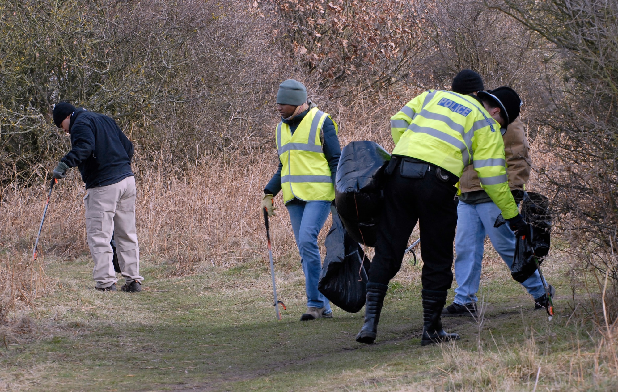RAF MILDENHALL, England – Tech. Sgt. Cheron Nieves (center), 100th Logistics Readiness Squadron, scans for litter as her fellow volunteers help cleanup Red Lodge March 6. The volunteers met at the Millennium Centre at 9 a.m. then started removing litter while contractors excavated large amounts of waste and litter on an adjoining street where major appliances and other large trash items were dumped.  (U.S. Air Force photo/Tech. Sgt. Kevin Wallace)