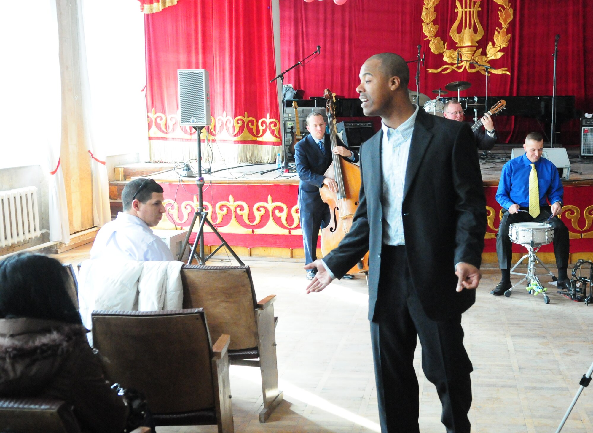 U.S. Air Force Master Sgt. Aaron Miles, vocalist of the U.S. Air Forces Central Public Affairs band “Reserve Generation,” sings to the audience during a concert at the Kurenkeyev College of Music, Bishkek, Kyrgyzstan, March 5, 2010.  When an unexpected power outage knocked out their electrical equipment, members of the band continued their concert to the delight of the audience. (U.S. Air Force photo/Senior Master Sgt. Mike Litsey/Released)