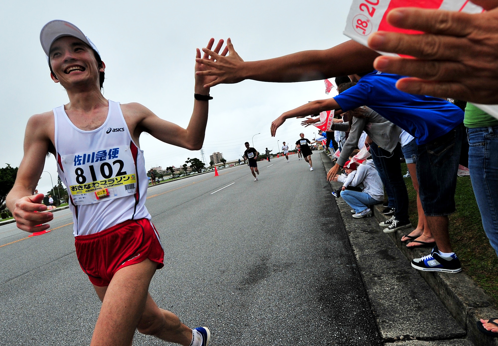 Volunteers cheer on American and Okinawan runners participating in the Okinawa Marathon March 7 at Kadena Air Base, Japan. Team Kadena volunteers encouraged and provided water to runners as they participated in the Kadena portion of the marathon. The marathon runs through nine different cities,towns,and villages in central Okinawa at a distance of 26.4 miles. The marathon aims to encourage people to enjoy running and increase their fitness level throughout Okinawa.  (U.S. Air Force photo/Tech. Sgt. Rey Ramon)    