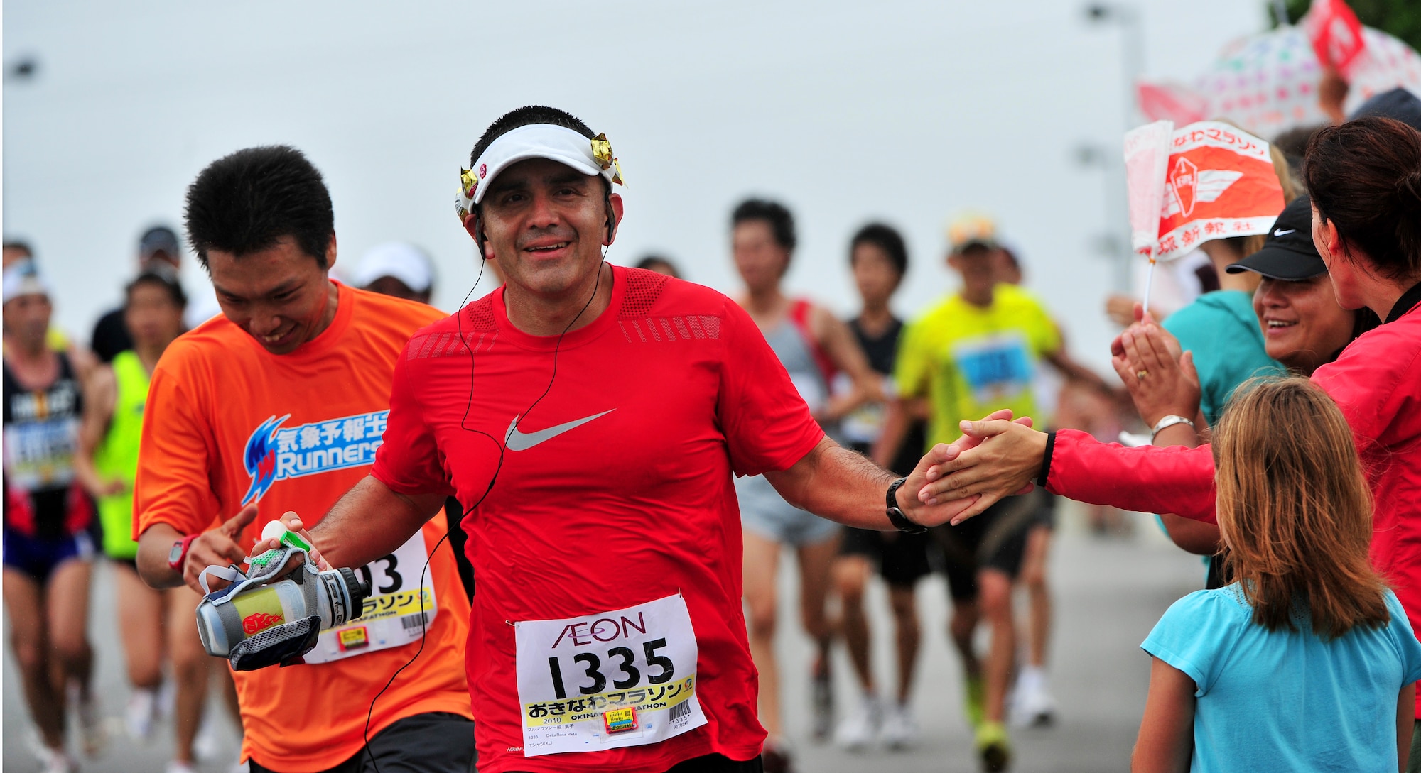 Americans and Okinawans participating in the Okinawa Marathon received cheers from volunteers March 7 at Kadena Air Base, Japan. Team Kadena volunteers encouraged and provided water to runners as they participated in the Kadena portion of the marathon. The marathon runs through nine different cities,towns,and villages in central Okinawa at a distance of 26.4 miles. The marathon aims to encourage people to enjoy running and increase their fitness level throughout Okinawa.  (U.S. Air Force photo/Tech. Sgt. Rey Ramon)     