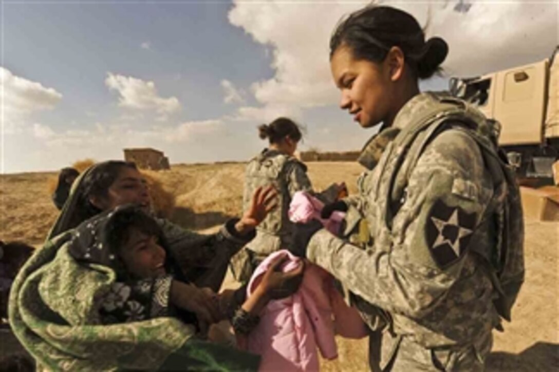 U.S. Army 1st. Lt. Ashley Higgins, with 4th Battalion, 23rd Infantry Regiment, gives jackets to Afghan girls in Boragay village in Zabul province, Afghanistan, on Dec. 4, 2009.  U.S. soldiers are conducting a humanitarian relief project to provide Afghan children with shoes, jackets, blankets, scarfs and caps.  