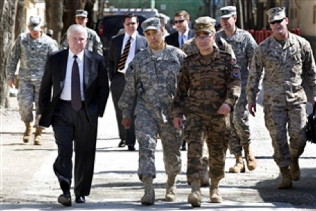 U.S. Defense Secretary Robert M. Gates, left,  walks with Maj. Wayne Don, advisor for the Mongolian Expeditionary Task Force assigned to NATO Training Mission Afghanistan, and Mongolian Lt. Col. Javkhlanbayar, senior representative of the contingent, on Camp Eggers in Kabul, March 8, 2010.  