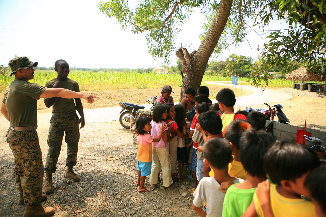 Lance Cpl. Lansana J. Kiazolu (right), a metal working specialist, and Chief Petty Officer Joshua Rosario, a hospital corpsman chief, both with Combat Logistics Battalion-31 (CLB-31), 31st Marine Expeditionary Unit (MEU), treat Marnay Primary School students to ice cream during recess, March 9. The residents of the local community observe daily as Armed Forces of the Philippines (AFP) and CLB-31, 31st MEU, servicemembers work together in rebuilding a two-room classroom and a water tower at Marnay Primary School during exercise Balikatan 2010 (BK ’10).