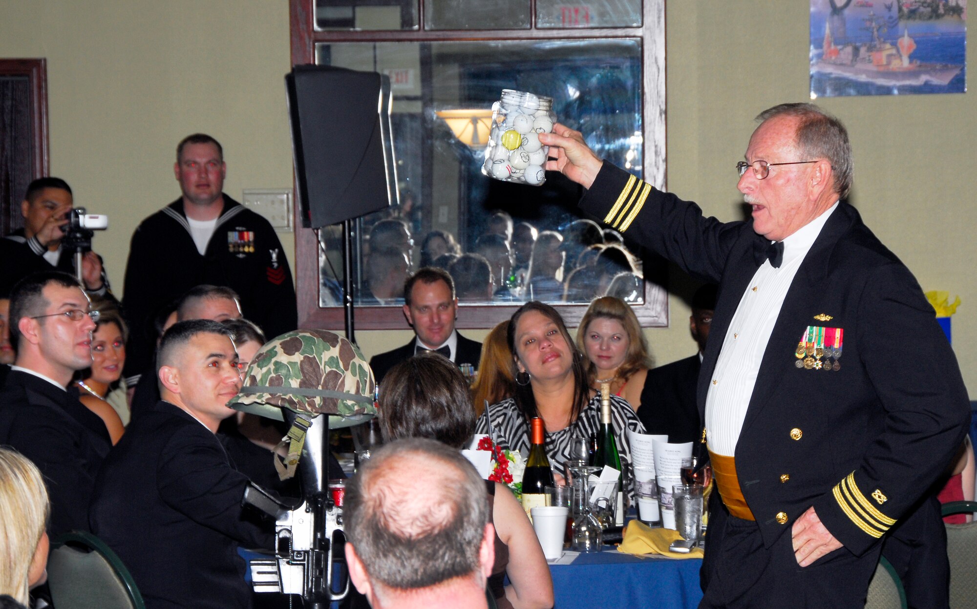 Retired  Lt. Cmdr. Earl Ramsey (right), Detachment Sheppard Naval Construction Training Center officer in charge, demonstrates his analogy of life values to the audience during the 68th Annual Seabee Ball in Wichita Falls, Texas, March 5. Commander Ramsey was the first Navy OIC at Sheppard. (U.S. Air Force photo/Harry Tonemah)