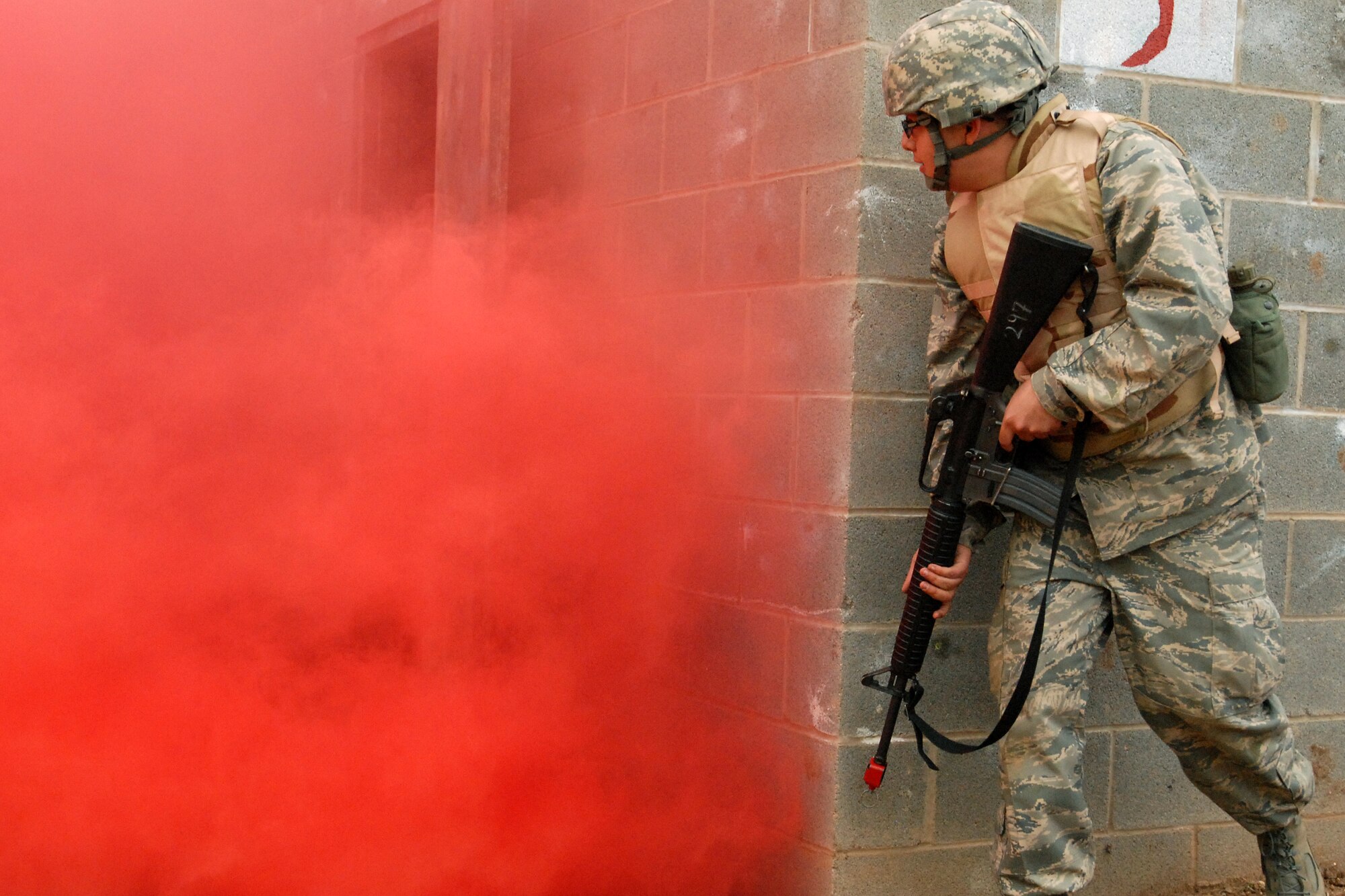 GOODFELLOW AIR FORCE BASE, Texas - Cadet John Lowery, a member of the Air Force Reserve Officer Training Corps Detachment 847, Angelo State University, San Angelo, Texas, waits for the smoke to clear before he moves to clear out a building while looking for a capture American during a training exercise, March 6, 2010.  The 17th Training Wing hosted cadets for 2 days during which cadets participated in class room instruction, field training and a deployment exercise at Goodfellow’s Forward Operating Base Sentinel. (U.S. Air Force photo/Master Sgt Randy Mallard)