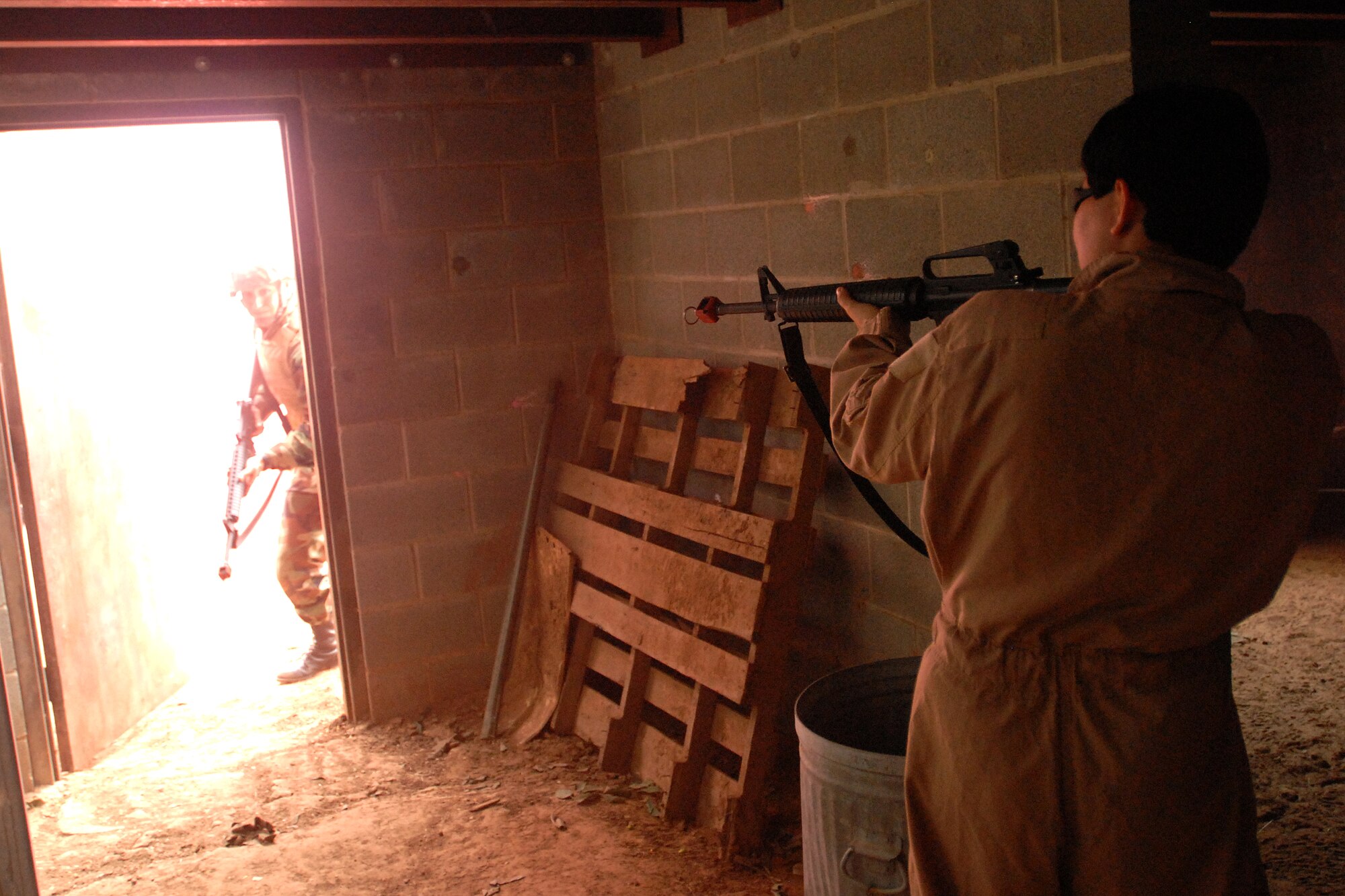 GOODFELLOW AIR FORCE BASE, Texas - A member of the opposing force prepares to engage cadets, from Air Force Reserve Officer Training Corps Detachment 847, Angelo State University, San Angelo, Texas, as they storm the building in search of a capture American during a training exercise, March 6, 2010. The 17th Training Wing hosted cadets for 2 days during which cadets participated in class room instruction, field training and a deployment exercise at Goodfellow’s Forward Operating Base Sentinel. (U.S. Air Force photo/Master Sgt Randy Mallard)