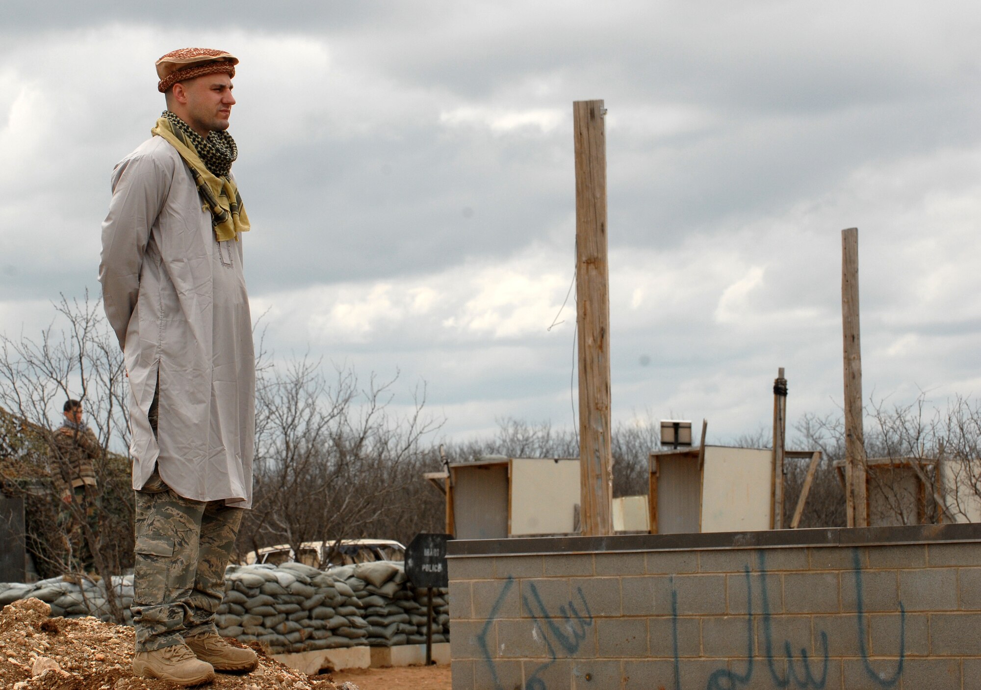 GOODFELLOW AIR FORCE BASE, Texas - Captain Jason DeSon, 17th Training Wing Judge Advocate, Goodfellow AFB, Texas, playing the part of the opposing force, waits for cadets, from Air Force Reserve Officer Training Corps Detachment 847, Angelo State University, San Angelo, Texas, to enter the local village during a patrol as a part of a training exercise, March 6, 2010. The 17th Training Wing hosted cadets for 2 days during which cadets participated in class room instruction, field training and a deployment exercise at Goodfellow’s Forward Operating Base Sentinel. (U.S. Air Force photo/Master Sgt Randy Mallard)