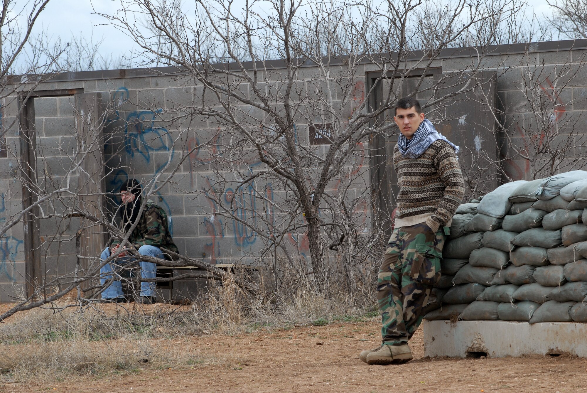 GOODFELLOW AIR FORCE BASE, Texas - Senior Airman Bryan Woods, 316th Training Squadron, Goodfellow AFB, Texas, playing the part of the opposing force, waits for cadets, from Air Force Reserve Officer Training Corps Detachment 847, Angelo State University, San Angelo, Texas, to enter the local village during a patrol as a part of a training exercise, March 6, 2010. The 17th Training Wing hosted cadets for 2 days during which cadets participated in class room instruction, field training and a deployment exercise at Goodfellow’s Forward Operating Base Sentinel. (U.S. Air Force photo/Master Sgt Randy Mallard)