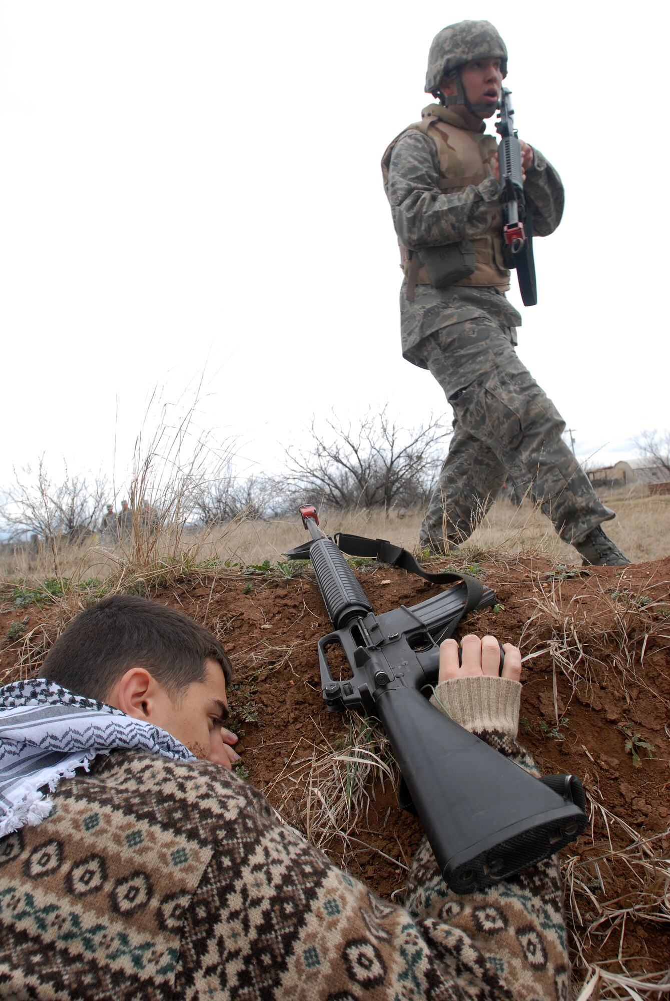 GOODFELLOW AIR FORCE BASE, Texas - Cadet Phillip Poundstone, a member of the Air Force Reserve Officer Training Corps Detachment 847, Angelo State University, San Angelo, Texas, walks past the body of an opposing force member after being attacked while on patrol, March 6, 2010.  The 17th Training Wing hosted cadets for 2 days during which cadets participated in class room instruction, field training and a deployment exercise at Goodfellow’s Forward Operating Base Sentinel. (U.S. Air Force photo/Master Sgt Randy Mallard)