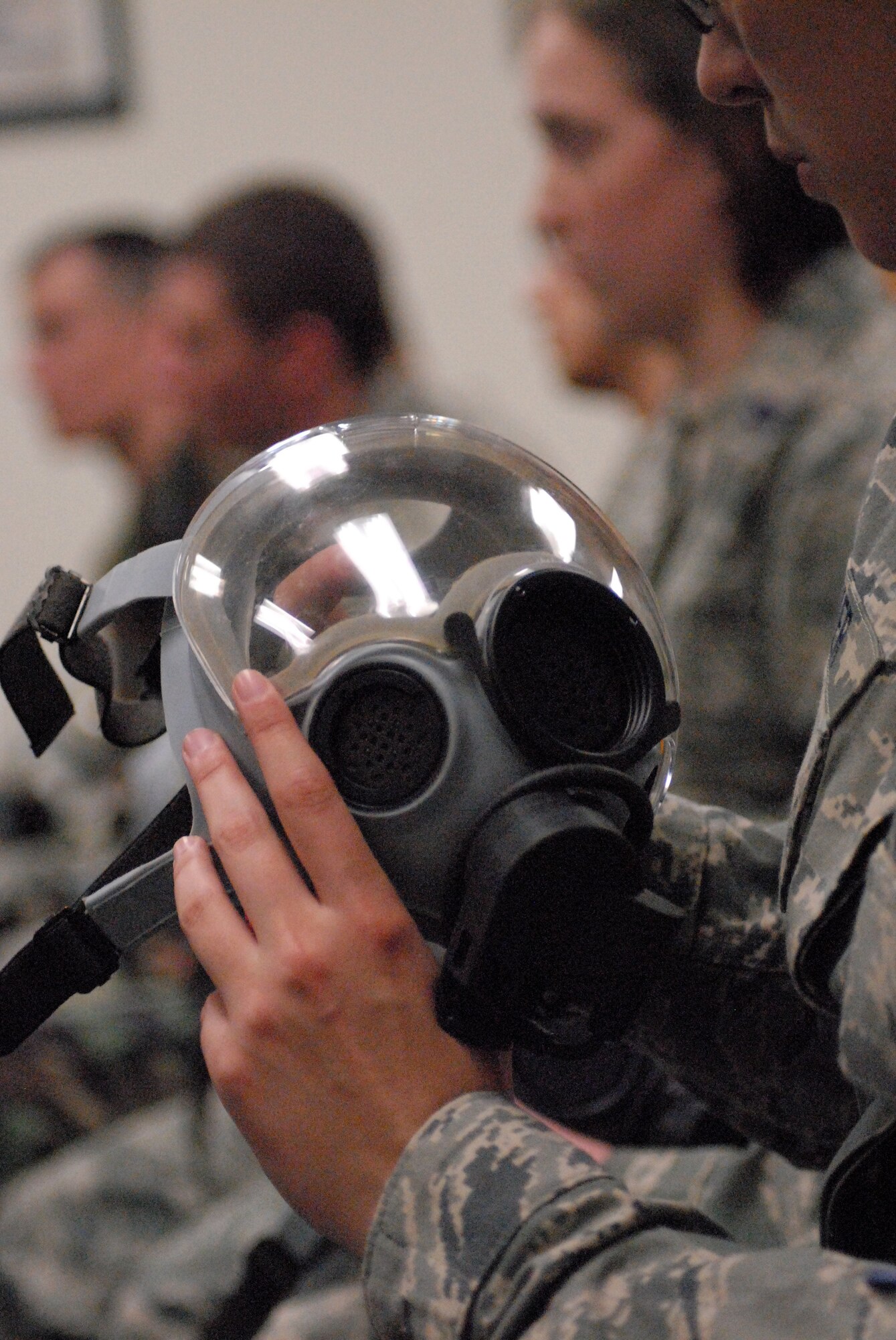 GOODFELLOW AIR FORCE BASE, Texas - Cadets from Air Force Reserve Officer Training Corps Detachment 847, Angelo State University, San Angelo, Texas, look over the MCU-2 protective mask as an instructor from the 17th Civil Engineering Squadron, Goodfellow AFB, Texas, explains the different parts of the mask, March 5, 2010. The 17th Training Wing hosted cadets from Detachment 847 for 2 days during which cadets participated in class room instruction, field training and a deployment exercise at Goodfellow’s Forward Operating Base Sentinel. (U.S. Air Force photo/Master Sgt Randy Mallard)