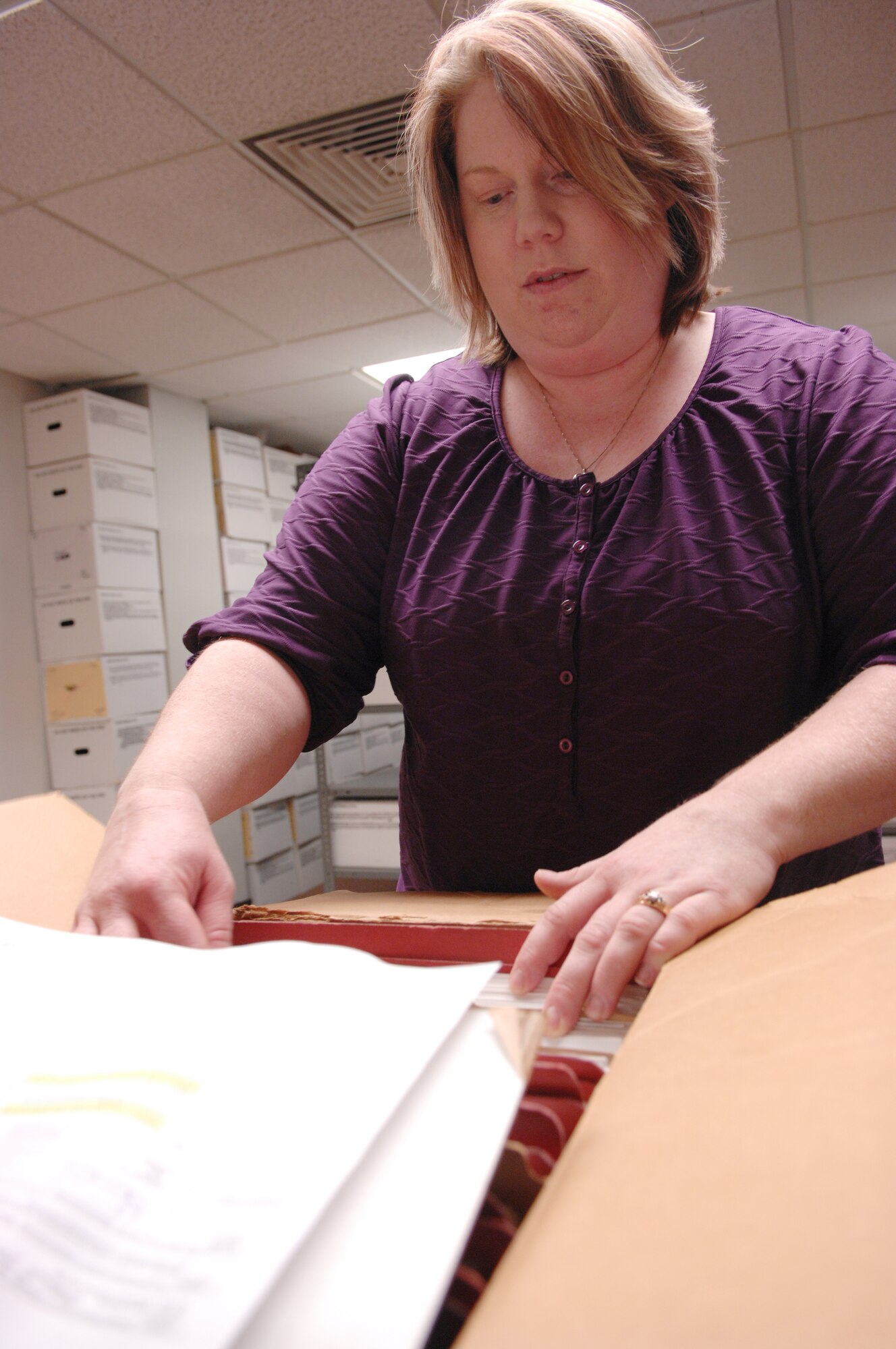 Erica Sims reviews files before placing them in storage March 2, 2010 Eielson Air Force Base, Alaska. The Base Records Management office oversees the records management program for Eielson and maintaining a staging area where approximately 400 cubic feet of records are stored. Mrs. Sims is a base records manager. (U.S. Air Force photo/Airman 1st Class Rachelle Coleman)