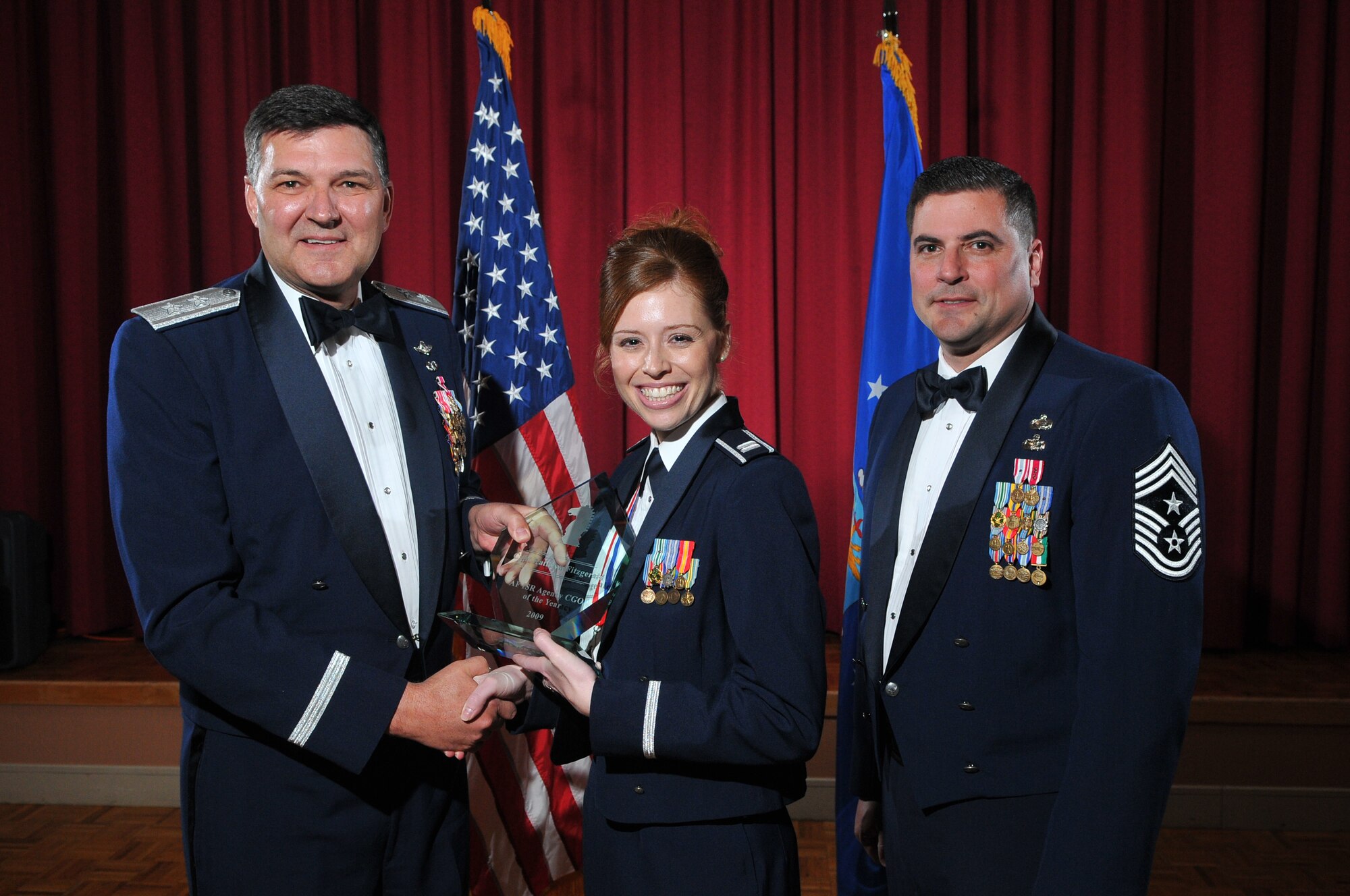 Capt. Kathryn Fitzgerald receives a plaque March 4 from Maj. Gen. Bradley Heithold, Air Force ISR Agency commander, and the agency’s command chief, Chief Master Sgt. Paul Weseloh for being the 2009 OAY in the company grade officer Category.