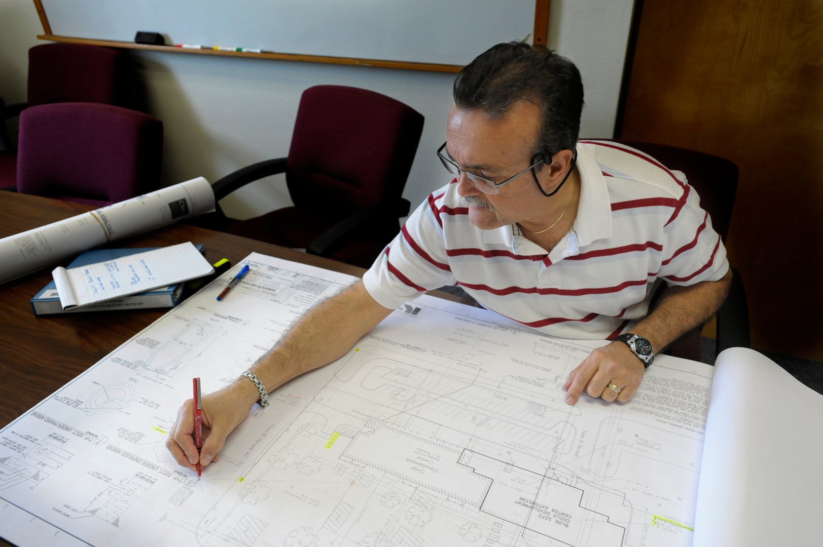 Antonio Matos, architect with the 902nd Civil Engineer Squadron, reviews plans for the Child Development Center expansion and renovation project which will increase space and improve the existing infrastructure resulting in double the capacity. (U.S. Air Force photo/Steve Thurow)