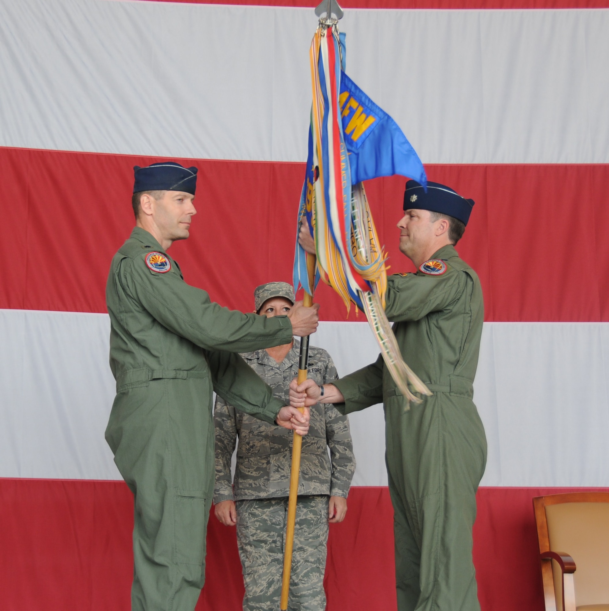 Lt. Col. David Garfield, 944th Operations Group commander, passes the 69th
Fighter Squadron guidon to Lt. Col. Steve Speckhard, 69th FS commander,
during the squadron's activation ceremony March 6 where the pilots of the
301st Fighter Squadron symbolically changed their patch to the 69th FS. The
301st FS, which traces its roots to the Tuskegee Airmen of World War II,
will continue its legacy with the next generation aircraft, the F-22 Raptor,
at Holloman Air Force Base, N.M., as a Reserve associate unit. The 69th FS
pilots will continue their reserve associate pilot training program with the
56th Fighter Wing here at Luke. (U.S. Air Force photo/Tech. Sgt. Susan
Stout)
