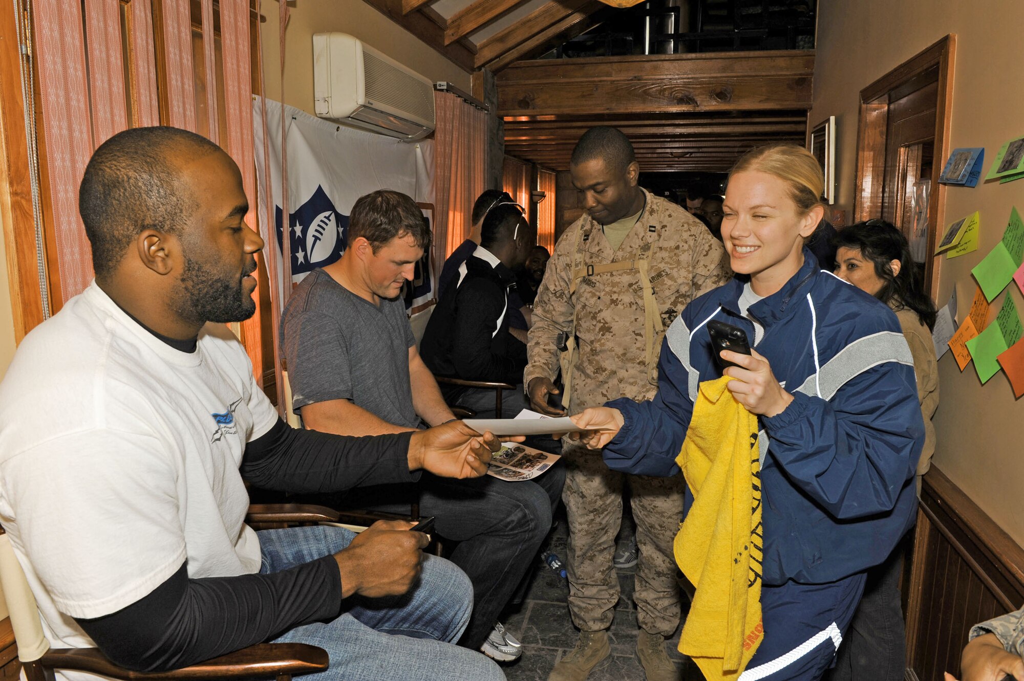 Mario Williams of the Houston Texans hands an autograph to Tech. Sgt. Kimberly Price during an autograph session March 5, 2010, at the Pat Tillman USO at Bagram Airfield, Afghanistan. Sergeant Price is assigned to the 455th Aeromedical Evacuation Squadron. (U.S. Air Force photo/Staff Sgt. Richard Williams)