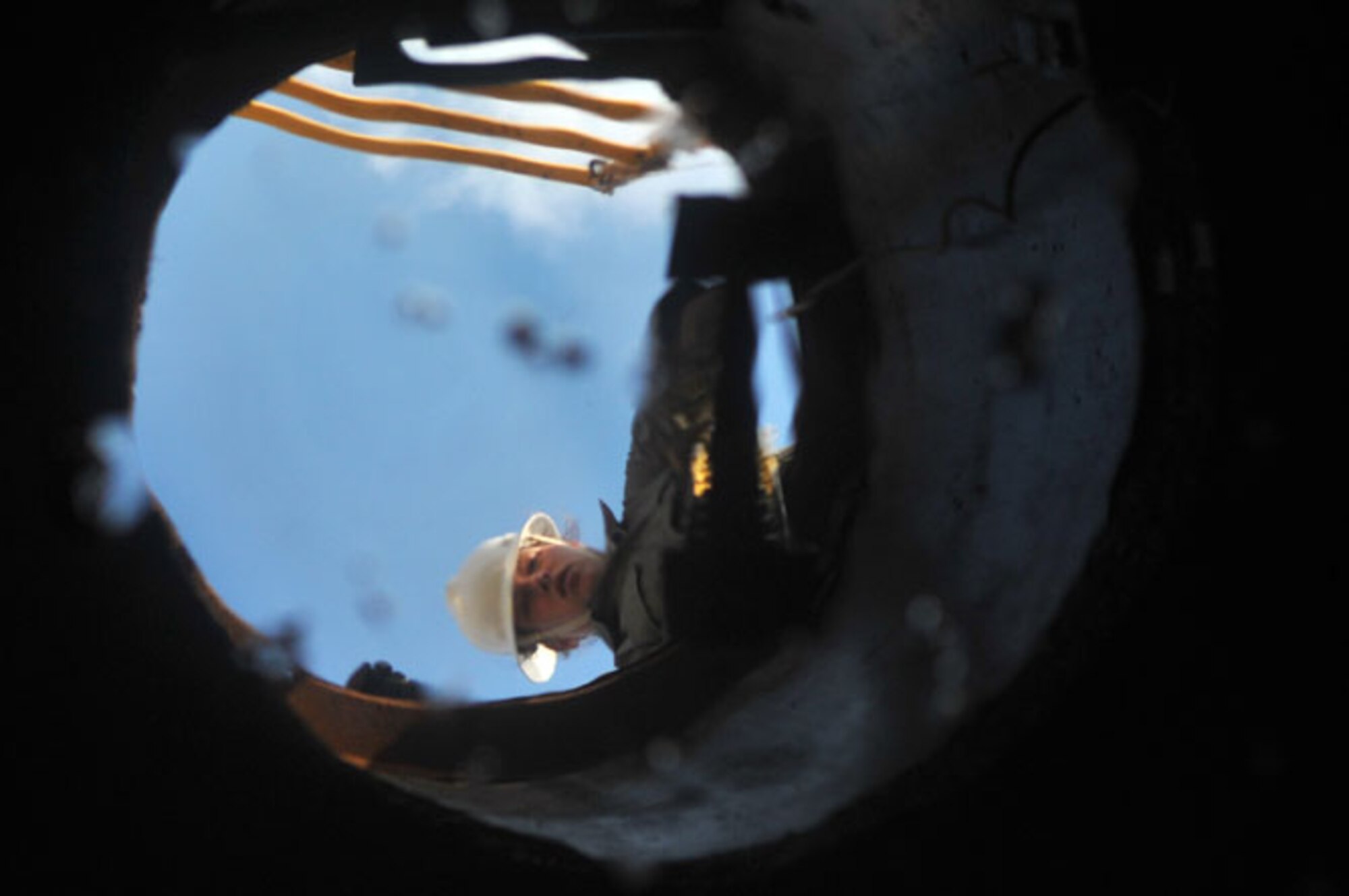 SCOTT AIR FORCE BASE, Ill -- Staff Sgt. Carla Schempp lowers a ladder into the manhole for Airman 1st Class Jacobs to get out March 2, 2010. The 375th Communication Squadron's cable maintenance element or Cable Dawgs are a vital to providing communication capability for Scott Air Force Base. The Cable Dawgs are charged with sustaining the voice systems in support of US Transportation Command, Air Mobility Command headquarters, 18th Air Force, 618th Tanker Airlift Control Center, three flying wings and more than 50 associate units. (U.S. Air Force photo by Senior Airman Teresa M. Jennings)