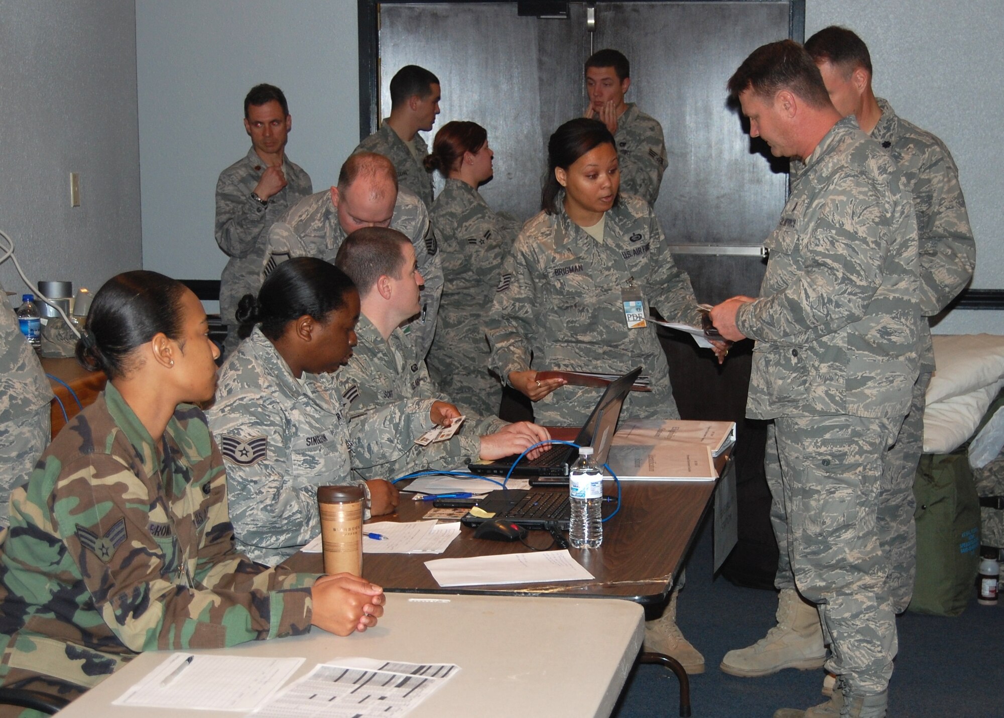 (Photo by Steve Pivnick)
Col. David Garrison, right foreground, 81st Medical Group deputy commander and deployed contingent commander, and Lt. Col. Christopher Morgan (partially visible), 81st Medical Support Squadron Readiness Flight commander and the  team’s health services administrator, lead the 81st MDG medics through the 81st Training Wing’s deployment processing line March 7 in the 81st MDG Hospital auditorium.  Almost 60 medics were processed during the morning before boarding the C-17 “Globemaster III” transport that was to fly them to San Antonio, en route to Chile, later in the afternoon.