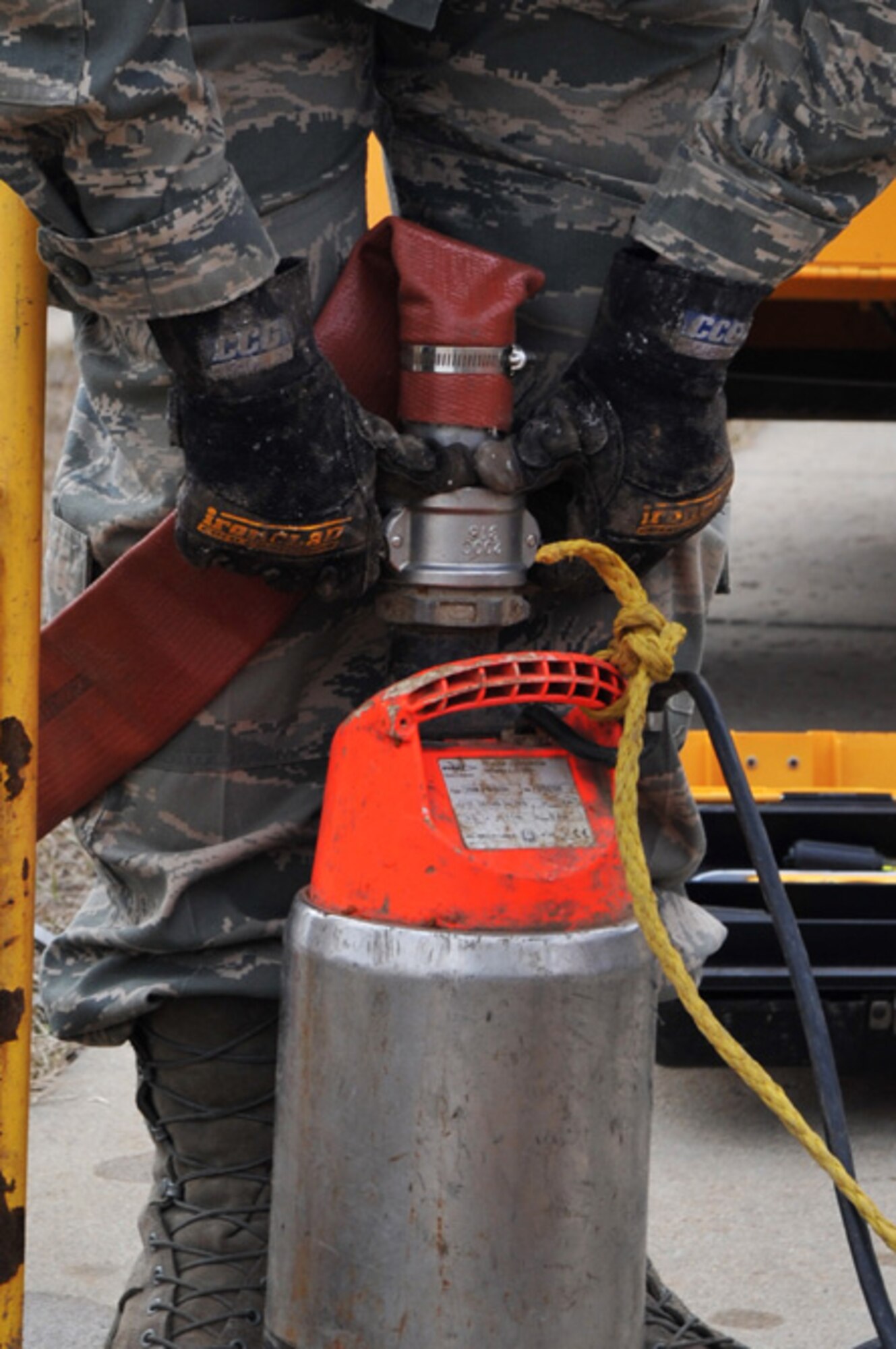 SCOTT AIR FORCE BASE, Ill -- An Airman attaches a hose to a sump pump that will be used to drain a manhole March 2, 2010. The 375th Communication Squadron's cable maintenance element or Cable Dawgs are a vital to providing communication capability for Scott Air Force Base. The Cable Dawgs are charged with sustaining the voice systems in support of US Transportation Command, Air Mobility Command headquarters, 18th Air Force, 618th Tanker Airlift Control Center, three flying wings and more than 50 associate units. (U.S. Air Force photo by Senior Airman Teresa M. Jennings)