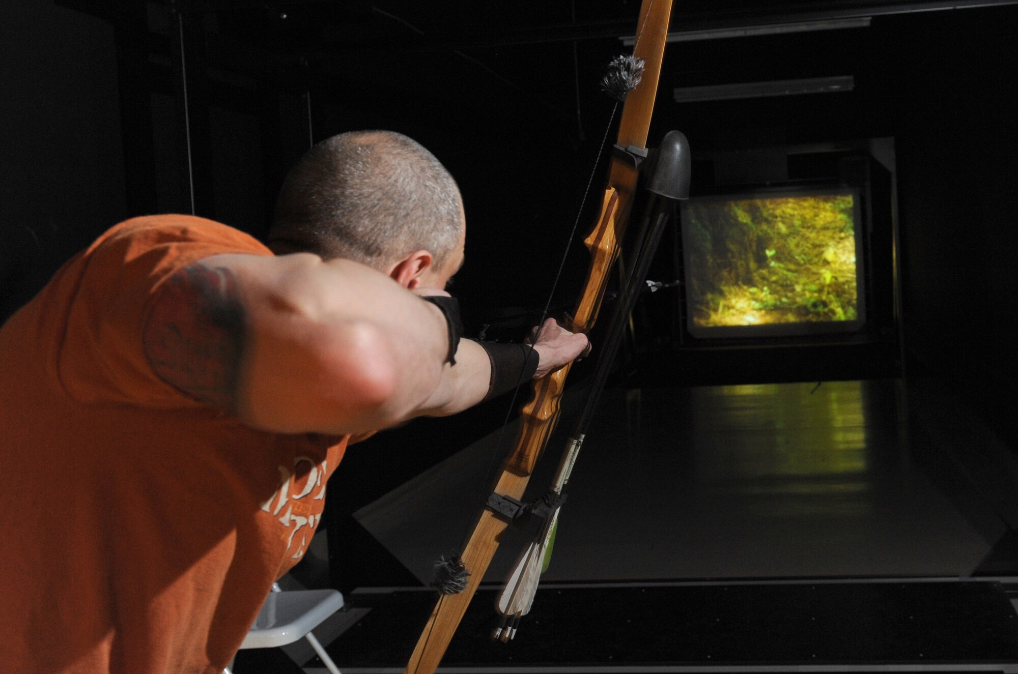 MINOT AIR FORCE BASE, N.D. – Tech. Sgt. Thomas Dow, 5th Bomb Wing public affairs web editor, fires an arrow in the archery simulator range at Minot Air Force Base March 8. The outdoor recreation center received the virtual range last September and is currently holding a league competition which began March 1.  The nine-week league will conclude April 24, with a trophy going to the top two-person team. (U.S. Air Force photo by Tech. Sgt. Lee A. Osberry Jr.)