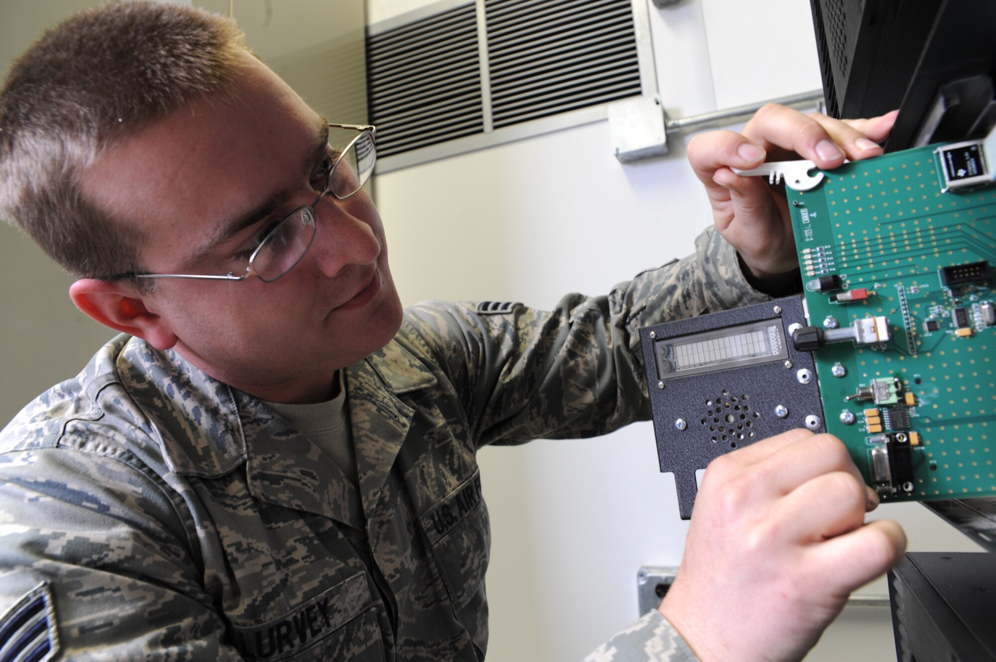Senior Airman Jacob Lurvey removes a repeater control card from a radio frequency trunking repeater on Joint Base Charleston during a recent repair Feb. 23. The repeater control card is just one of many electronic components necessary for radio communication with base agencies through the trunking repeater, which allows multiple radio frequency users to communicate on a minimum number of frequencies. Airman Lurvey is a radio frequency system transmission technician with the 628th Communications Squadron. (U.S. Air Force photo/Senior Airman Katie Gieratz)