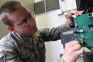Senior Airman Jacob Lurvey removes a repeater control card from a radio frequency trunking repeater on Joint Base Charleston during a recent repair Feb. 23. The repeater control card is just one of many electronic components necessary for radio communication with base agencies through the trunking repeater, which allows multiple radio frequency users to communicate on a minimum number of frequencies. Airman Lurvey is a radio frequency system transmission technician with the 628th Communications Squadron. (U.S. Air Force photo/Senior Airman Katie Gieratz)