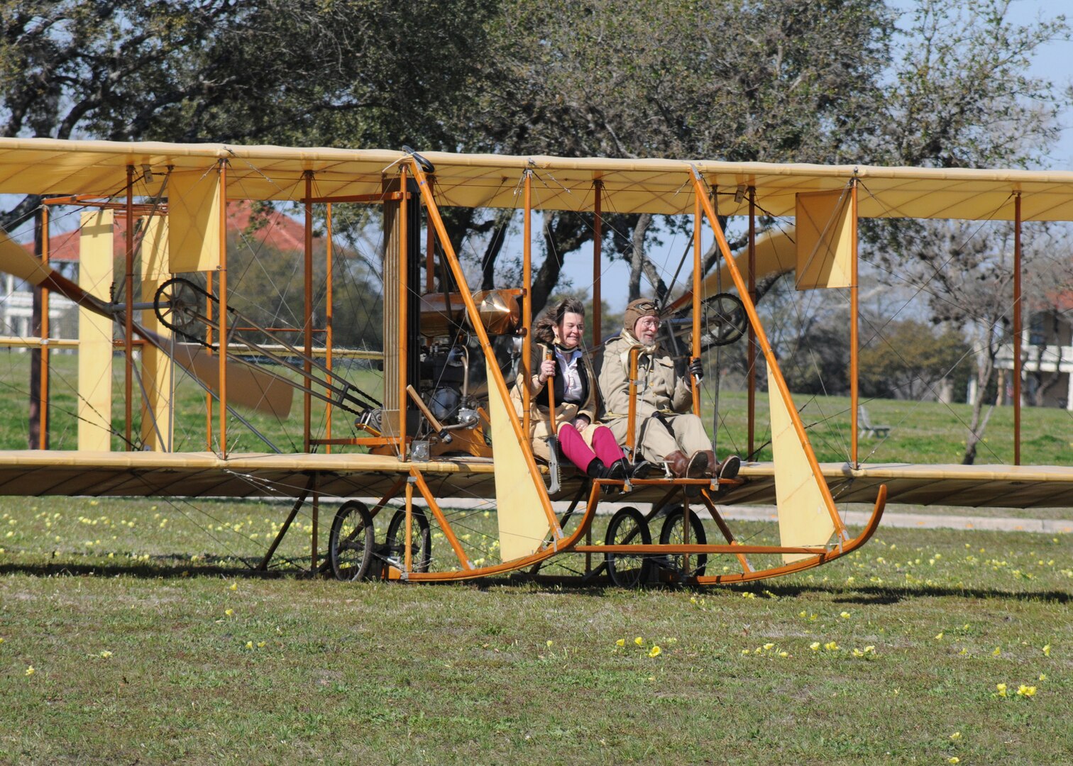 Amanda Wright Lane, great grandniece of the Wright Brothers, takes a ride in a Wright Flyer with pilot Don Gum down the Fort Sam Houston Parade Ground, March 2, during the Foulois Centennial Military Flight Celebration event marking the 100th Anniversary of military aviation. (U.S. Air Force photo by Dave Terry)