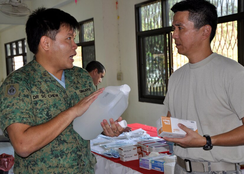 Maj. (Dr.) Nishiguchi, a dentist from an Air Force Reserve unit at Joint Base Pearl Harbor Hickam, Hawaii, discusses the supply situation with a dentist from the Republic of Singapore Air Force prior to a humanitarian mission in Nakhon Ratchasima Province, Thailand, March 4, 2010.  Dr. Nishiguchi and approximately 500 other U.S. Air Force members are participating in Cope Tiger 2010, an annual multilateral training exercise with the Royal Thai Air Force and Army and the Republic of Singapore Air Force that includes humanitarian assistance. Exercises such as Cope Tiger build strong relationships with nations in the region and enhance interoperability as the U.S. trains side-by-side with regional military forces. Dr. Nishiguchi has a private practice in Honolulu and joined the Air Force Reserve so he could go on humanitarian missions. (U. S. Air Force photo/Capt. Christy Stravolo)