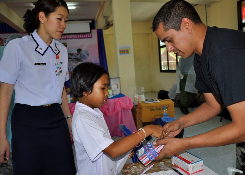 Air Force Staff Sgt. Larry Dickson, a dental technician from Joint Base Pearl Harbor Hickam, Hawaii, gives a 7-year-old Thai girl her choice of colored toothbrushes during a humanitarian mission in Nakhon Ratchasima Province, Thailand, March 4, 2010.  Sergeant Dickson and approximately 500 other U.S. Air Force members are participating in Cope Tiger 2010, an annual multilateral training exercise with the Royal Thai Air Force and Army and the Republic of Singapore Air Force that includes humanitarian assistance. Exercises such as Cope Tiger build strong relationships with nations in the region and enhance interoperability as the U.S. trains side-by-side with regional military forces. (U. S. Air Force photo/Capt. Christy Stravolo)