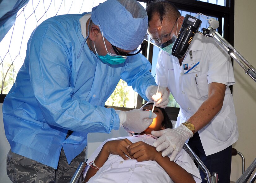 Capt. (Dr.) Michael Fernandez, a dentist from an Air Force Reserve unit in Guam, gives a local anesthetic to a 7-year-old Thai girl in preparation for a tooth extraction with some assistance from a Royal Thai Air Force medical technician in Nakhon Ratchasima Province, Thailand, March 4, 2010.  Dr. Fernandez and approximately 500 other U.S. Air Force members are participating in Cope Tiger 2010, an annual multilateral training exercise with the Royal Thai Air Force and Army and the Republic of Singapore Air Force that includes humanitarian assistance. Exercises such as Cope Tiger build strong relationships with nations in the region and enhance interoperability as the U.S. trains side-by-side with regional military forces.  Dr. Fernandez has had a private dental practice in Guam for 15 years and joined the Air Force Reserve so he could go on humanitarian missions.  (U. S. Air Force photo/Capt. Christy Stravolo)