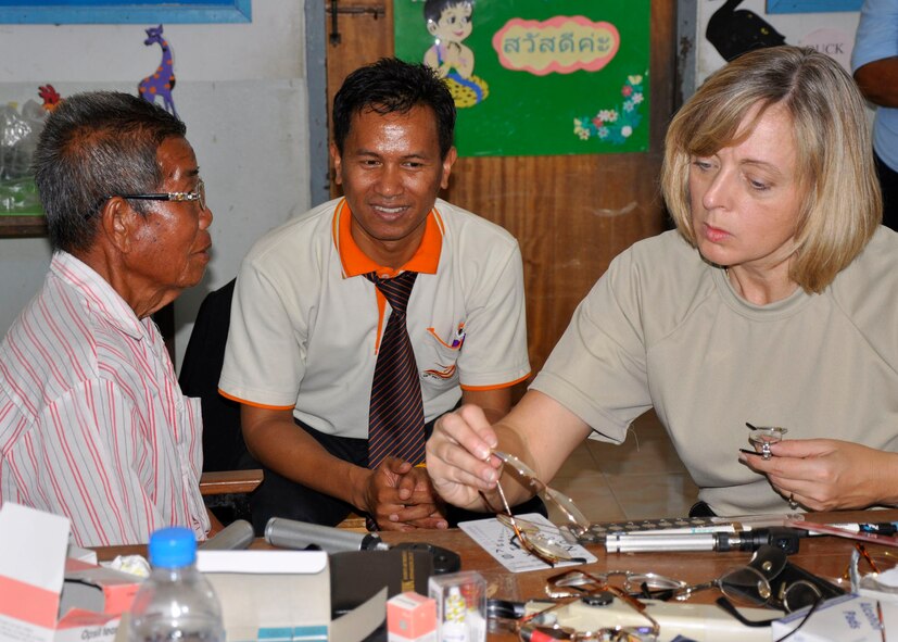 Maj. (Dr.) Patti Fries, an optometrist from the Missouri Air National Guard, searches for the best pair of prescription glasses for a Thai gentleman in Nakhon Ratchasima Province, Thailand, March 4, 2010.  Dr. Fries and approximately 500 other U.S. Air Force members are participating in Cope Tiger 2010, an annual multilateral training exercise with the Royal Thai Air Force and Army and the Republic of Singapore Air Force that includes humanitarian assistance. Exercises such as Cope Tiger build strong relationships with nations in the region and enhance interoperability as the U.S. trains side-by-side with regional military forces.  Dr. Fries is a native of Omaha, Nebraska. (U. S. Air Force photo/Capt. Christy Stravolo)
