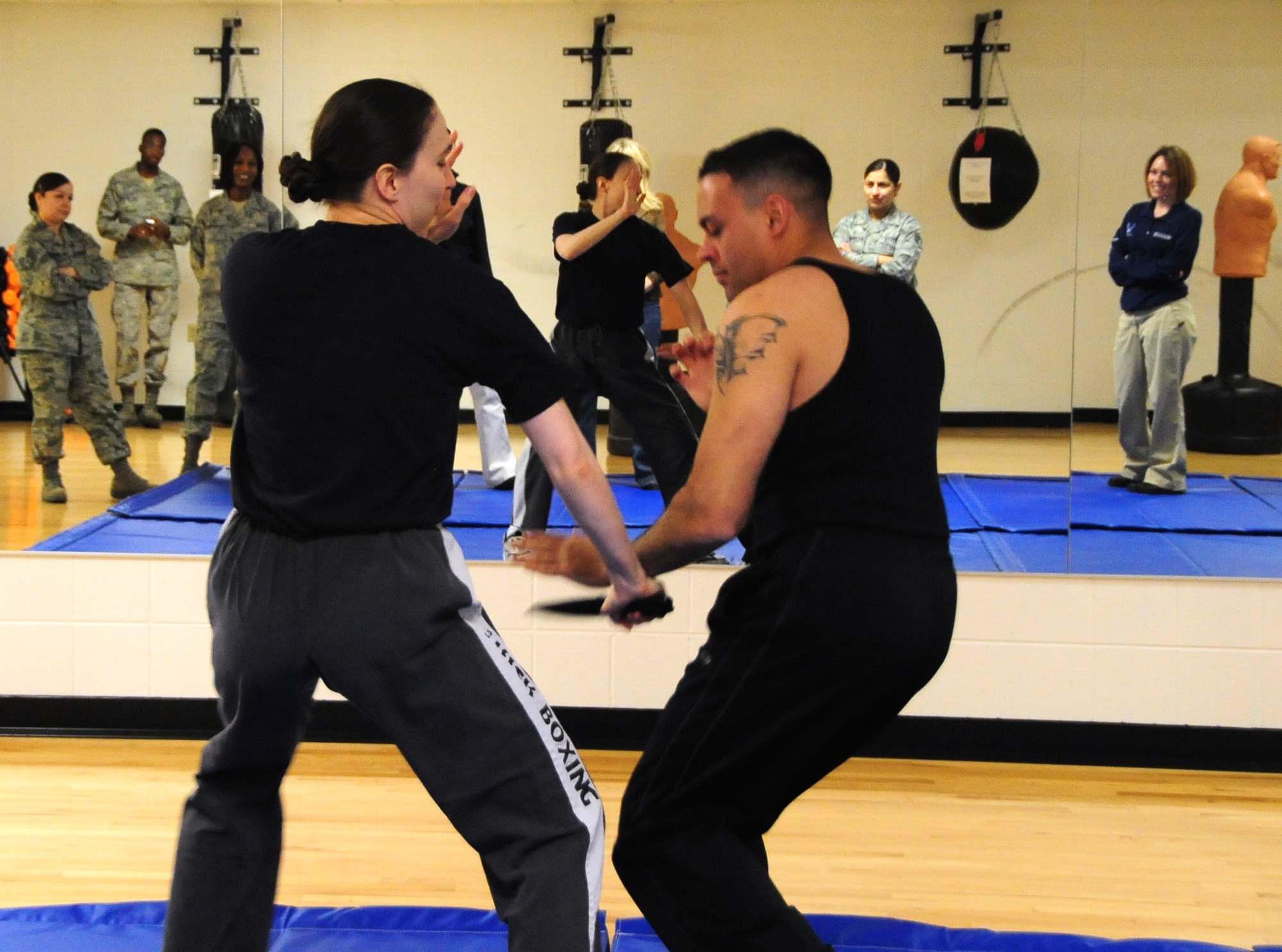 ELLSWORTH AIR FORCE BASE, S.D. -- (Left to right) Tech. Sgt. Elizabeth Nagy, 28th Bomb Wing NCO in charge of equal opportunity and Airman 1st Class Jarad Denton, 28 BW public affairs staff writer, show defensive techniques to use against an attacker with a weapon during a self-defense class focused on real-life situations, March 5.  The class, which was targeted to women, taught participants how to counter and defend themselves in various situations they may encounter. (U.S. Air Force photo/Airman 1st Class Anthony Sanchelli)
