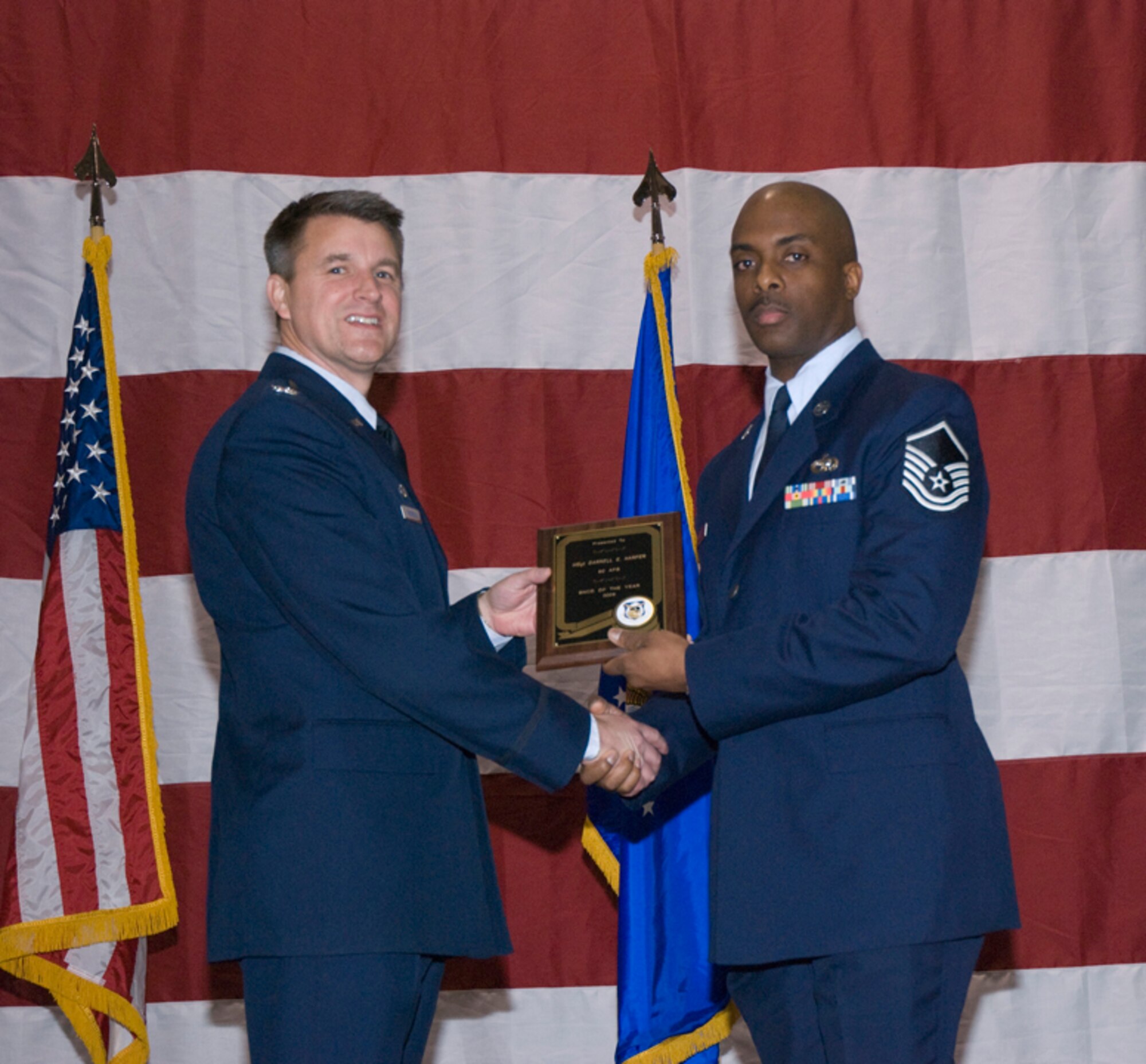 Colonel Heath J. Nuckolls, commander, 94th Airlift Wing, presents the 2009 Senior Non-commissioned Officer of the Year award to Master Sgt. Darrell E. Harper, air transportation craftsman, 80th Aerial Port Squadron at the wing commander’s call March 6. (U.S. Air Force photo/Staff Sgt. Samuel H. Hunt)