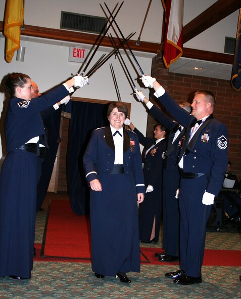 JOINT BASE LEWIS-MCCHORD, Wash.- Lt. Col. Carla Pelster, 446th Maintenance Operations Flight commander here, walks through the First Sergeants' Sword Arch in honor of her troop, Capt. Frank Bonnin, 446th MOF, who earned the 2009 446th Airlift Wing Company Grade Officer of the Year Award at the 446th AW Annual Awards Banquet at the McChord Consolidated Clubs here March 6. Captain Bonnin was unable to accept the award because is currently deployed to Turkmenistan. (U.S. Air Force photo/Tech. Sgt. Heather Normand)