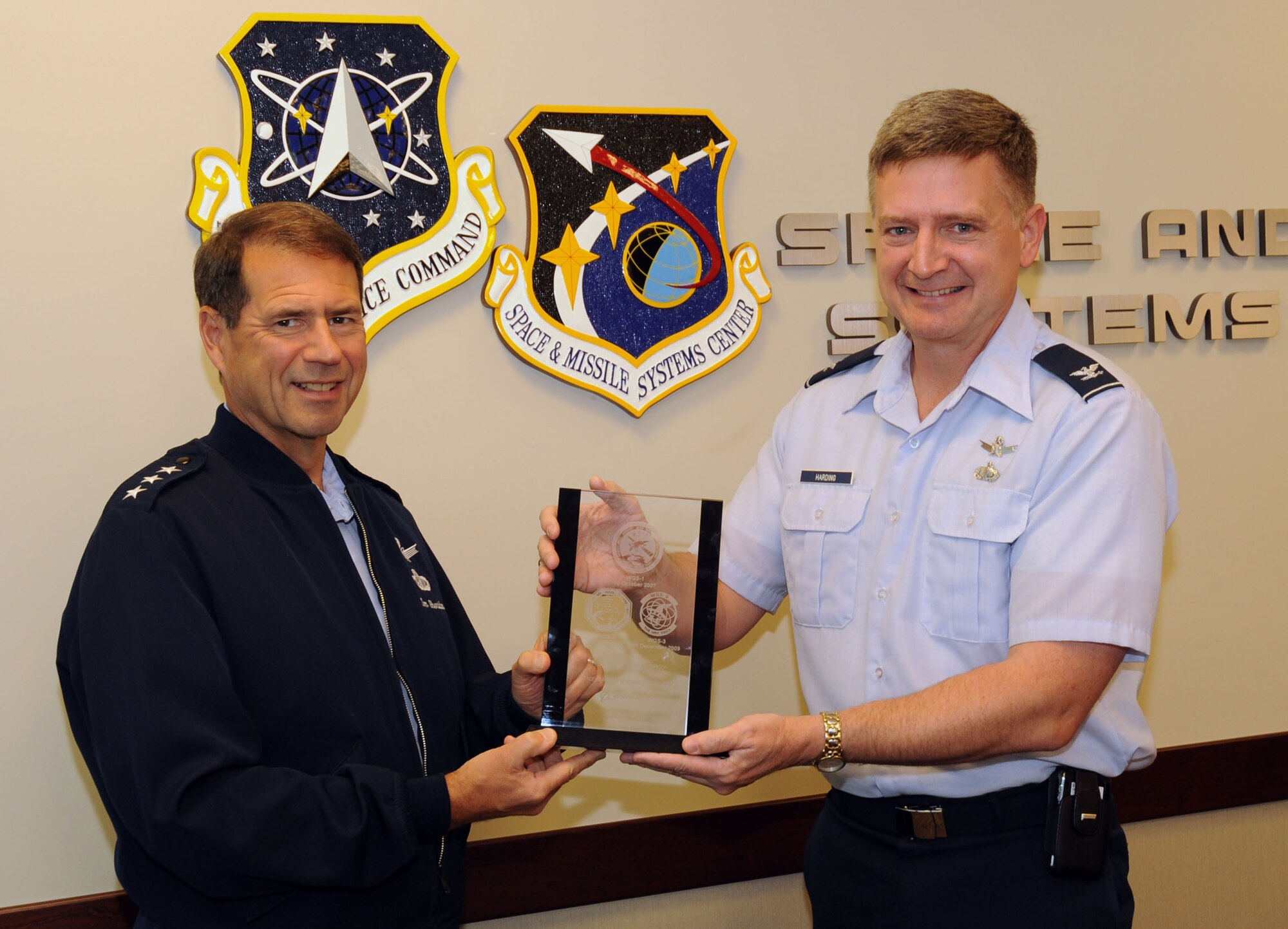 Lt. Gen. Tom Sheridan, SMC commander, receives a commemorative plaque from Col. William Harding, Military Satellite Systems Wing deputy commander, March 8.  The plaque was presented to SMC by The Boeing Corporation to mark the completion of the Wideband Global SATCOM Block I satellites. (Photo by Lou Hernandez)
