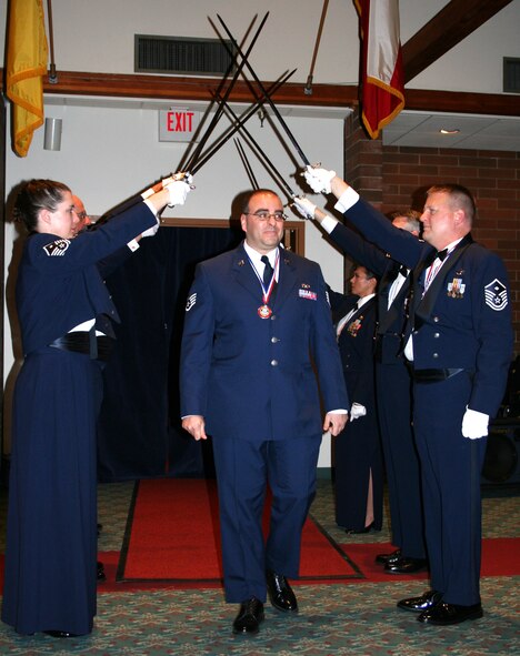 JOINT BASE LEWIS-MCCHORD, Wash.- Staff Sgt. John Lewis, 446th Maintenance Operations Flight here, walks through the First Sergeant Sword Arch in honor of him earning the 2009 446th Airlift Wing NCO of the Year Award at the 446th AW Annual Awards Banquet at the McChord Consolidated Clubs here March 6. Sergeant Lewis was the 2009 NCO winner for the fourth quarter. (U.S. Air Force photo/Tech. Sgt. Heather Normand)