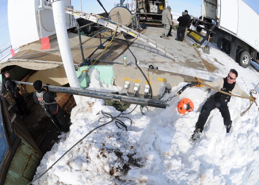MINOT AIR FORCE BASE, N.D. – Members of the 91st Missile Maintenance Squadron missile handling team prepare to set up an environmental cover during the removal of the last 2012 downstage March 5. The downstage is comprised of three stages of solid rocket fuel and is over 40 ft. long and weighs 68,000 pounds. Once a downstage is removed, it is returned to Hill Air Force Base, Utah for maintenance and inspections. (U.S. Air Force photo by Senior Airman Sharida Jackson)
