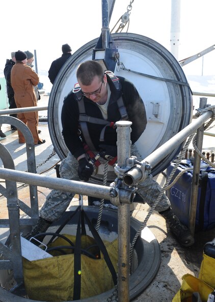 MINOT AIR FORCE BASE, N.D. – Senior Airman Timothy Vega, 91st Missile Maintenance Squadron missile maintenance team technician, lowers equipment into a capsule during the removal of the last 2012 downstage March 5. The downstage is comprised of three stages of solid rocket fuel and is over 40 ft. long and weighs 68,000 pounds. Once a downstage is removed, it is returned to Hill Air Force Base, Utah for maintenance and inspections. (U.S. Air Force photo by Senior Airman Sharida Jackson)
