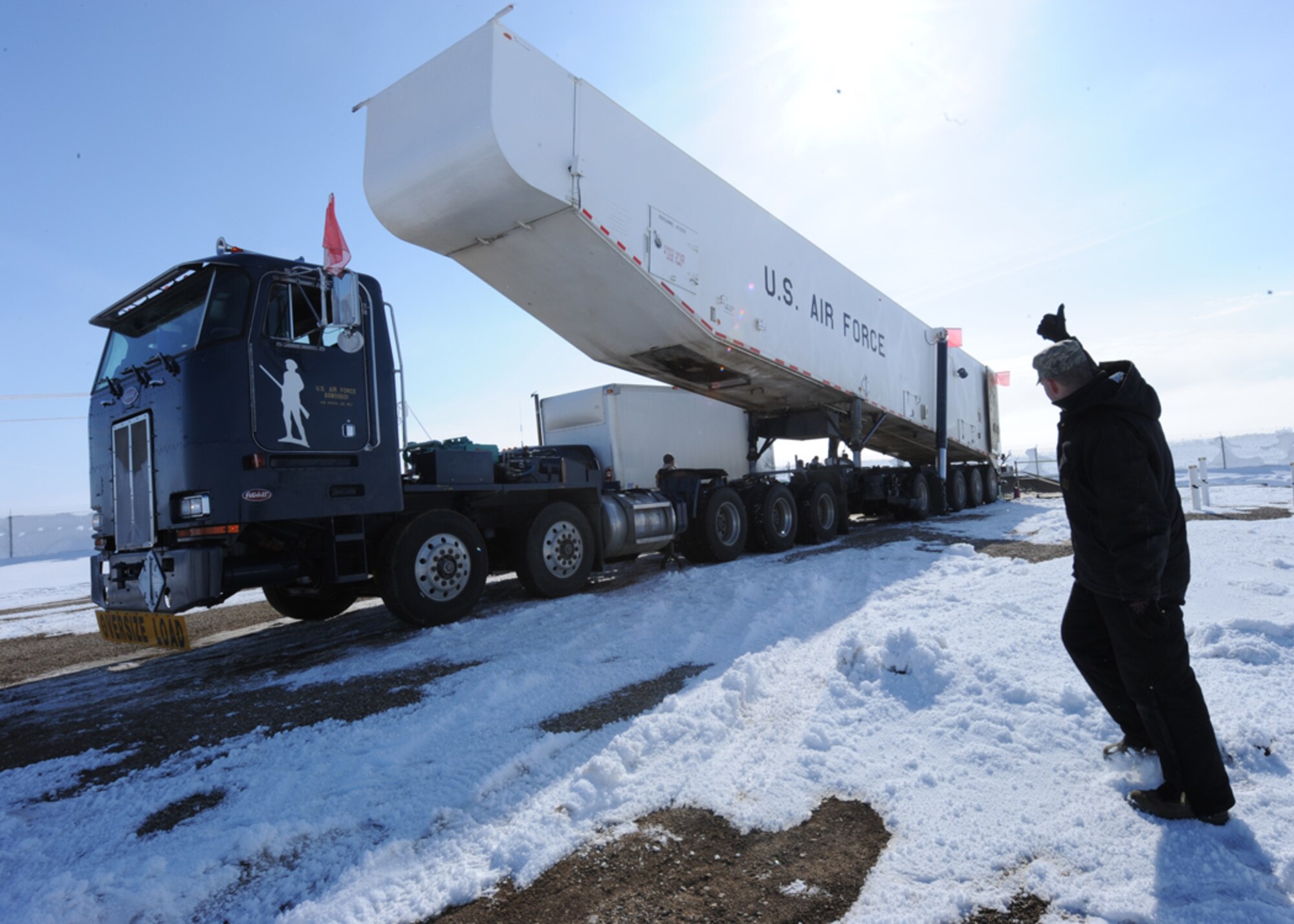 MINOT AIR FORCE BASE, N.D. – Master Sgt. Derek McCurry, 91st Missile Maintenance Squadron missile handling team noncommissioned officer-in-charge, gives a signal to raise the container on a Transporter Erector during the removal of the last 2012 downstage March 5. The downstage is comprised of three stages of solid rocket fuel and is over 40 ft. long and weighs 68,000 pounds. Once a downstage is removed, it is returned to Hill Air Force Base, Utah for maintenance and inspections. (U.S. Air Force photo by Senior Airman Sharida Jackson)