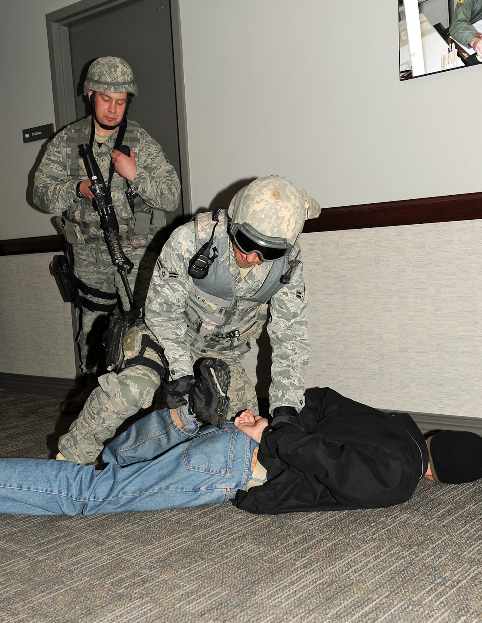 21st Security Forces Squadron Airmen detain a suspect Feb. 23 in the 21st Space Wing Headquarters Building 845 as part of the quarterly Condor Crest exercise. The suspect began a shooting spree in Eagle Park and then ran into the headquarters building. The four-day exercise simulated active shooters on Peterson Air Force Base and was designed to test building lockdown, medical and fire response and security forces reaction time. Condor Crest exercises also help ensure the 21st SW is able to complete its mission of professionally operating, supporting and protecting its personnel and resources during actual incidents. (U.S. Air Force photo/Roberta McDonald)